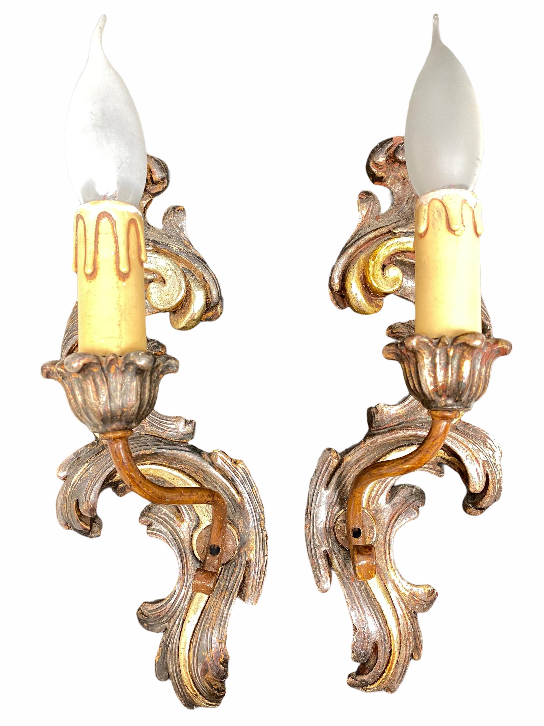 Add a touch of opulence to your home with this charming pair of sconces. Perfect gilt and silvered wood and stucco to enhance any chic or eclectic home. We'd love to see it hanging in an entryway as a charming welcome home. Built in the 1960s, in