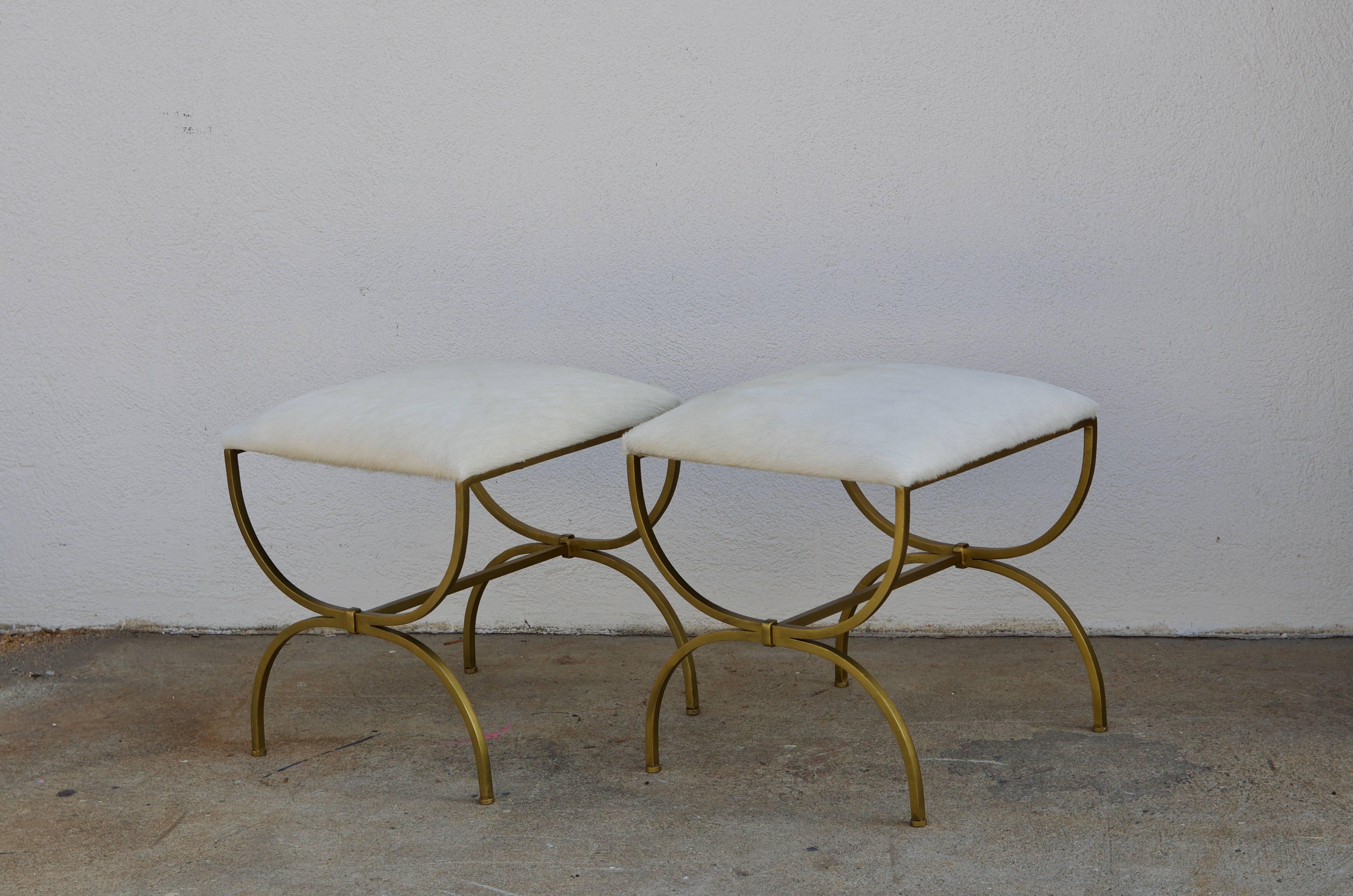 Pair of gilt wrought iron and hide 'Strapontin' stools by Design Frères, in the style of Gilbert Poillerat.