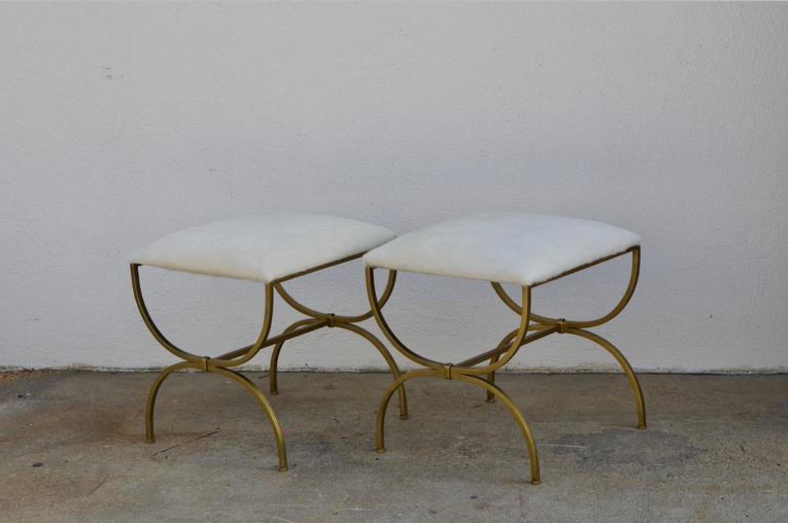Pair of gilt wrought iron and hide stools by Design Frères, in the style of Gilbert Poillerat.