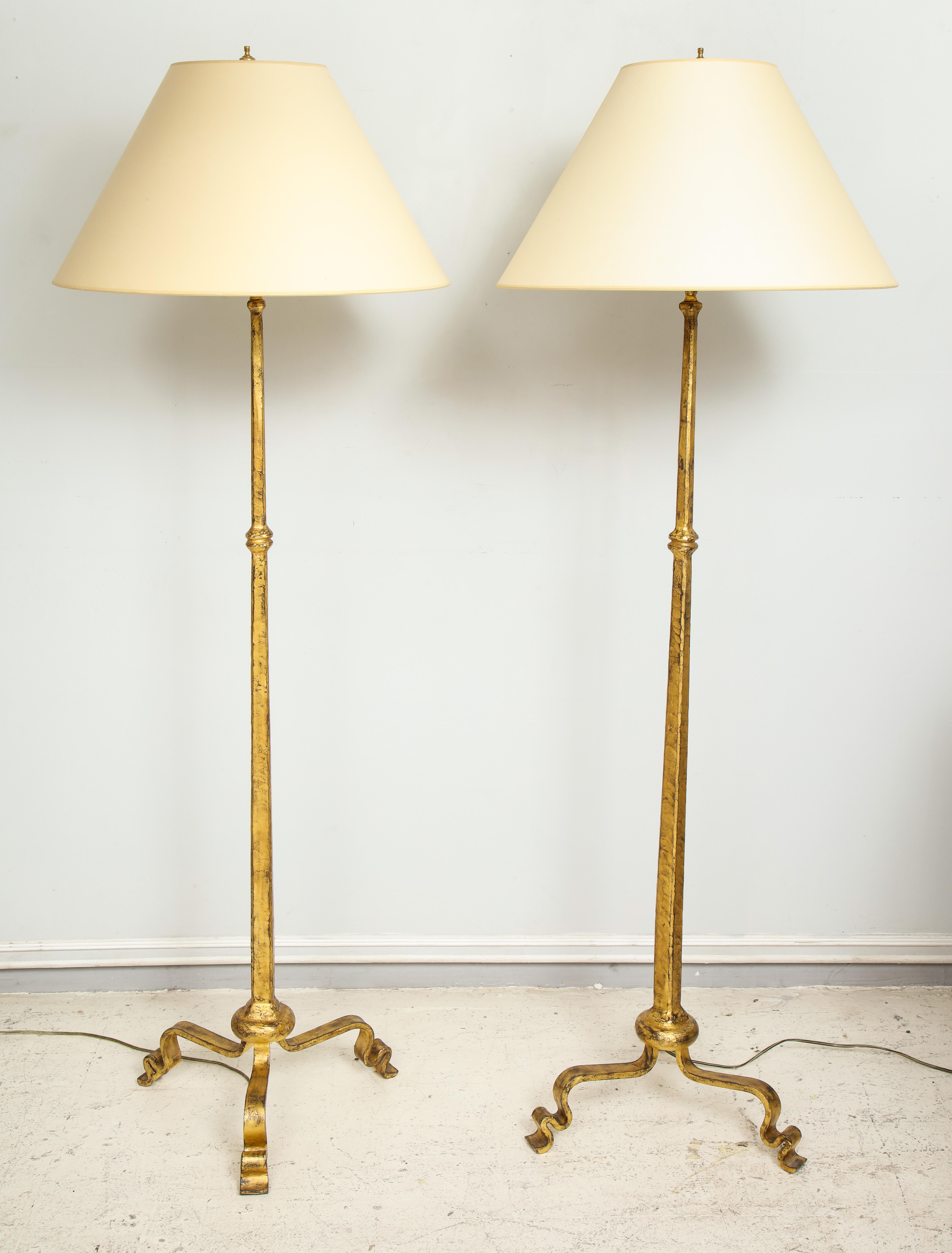 Pair of gilt wrought iron floor lamps in the Ramsay Manner, shades included.

Measurements are 62
