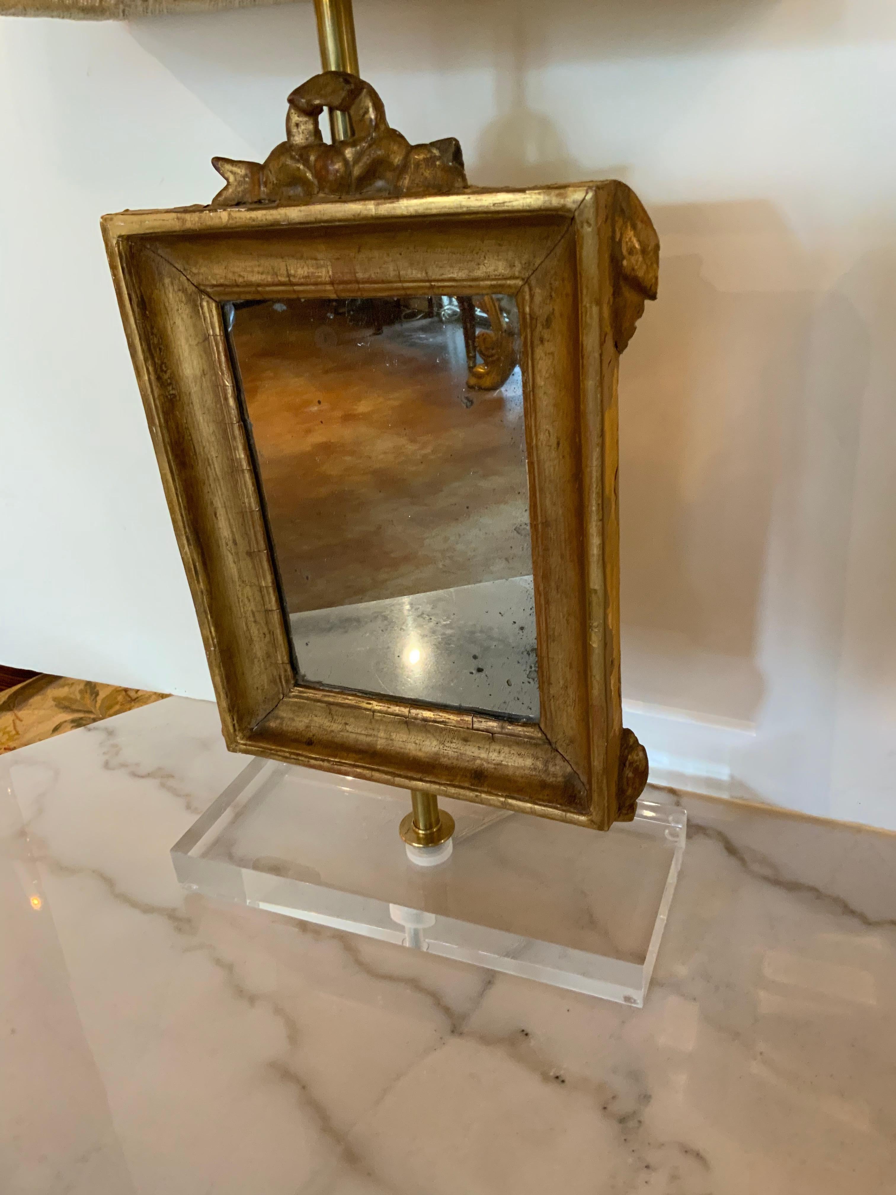 The mirrors with cove-molded frames, mounted on acrylic bases with shades.
The mirrors are 19th c.