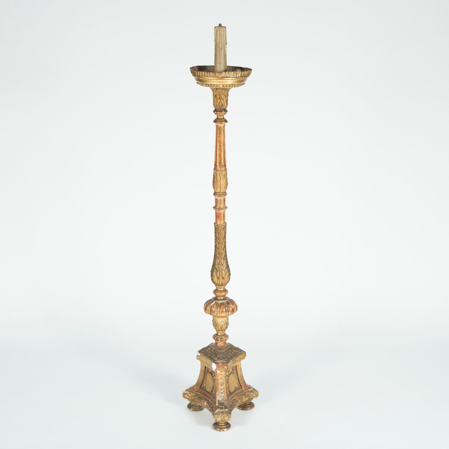 A pair of mid-19th century Italian giltwood candelabra with original gilding, the stems are carved with floral motifs and the triform base has a cartouche to each side. 

The candelabra have been previously wired for electricity, this can be
