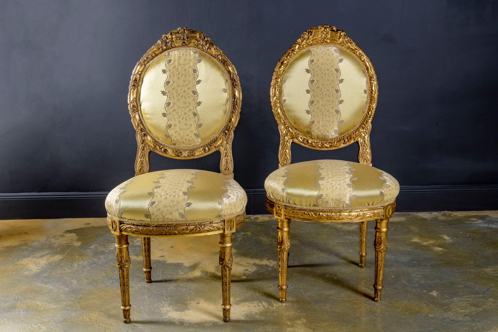 Pair of very well proportioned, elegant and chic Louis XVI style wood and gold leaf gilded chairs created very probably by Maison Jansen. 
Each chair with curved oval-shaped padded back and seat, reupholstered in prestigious very high quality Damask