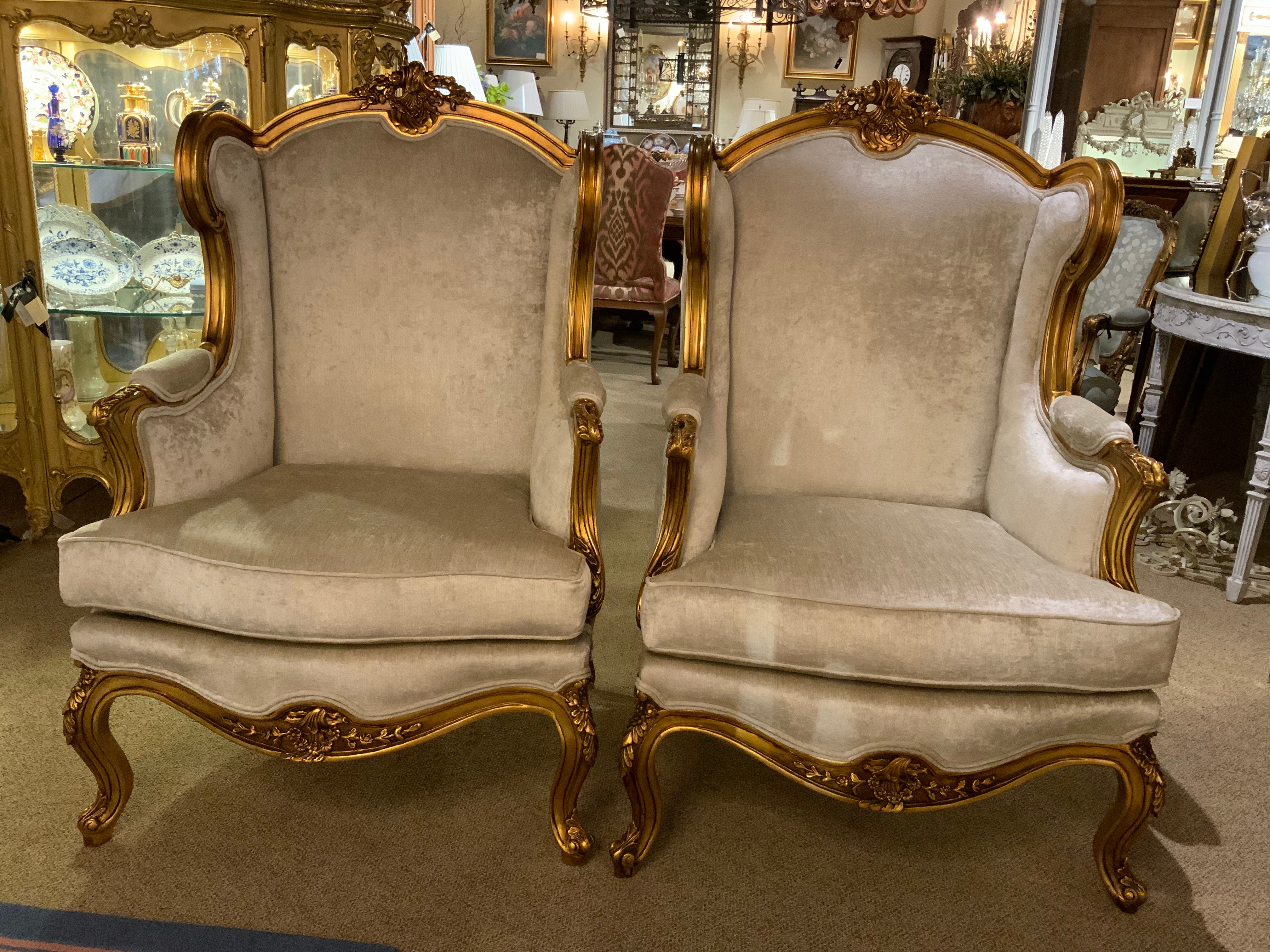 Pair of Louis XV-Style giltwood chairs with a creamy white new upholstery 
The carving is very well done in great detail exhibiting scrolls and foliate
Design. They are filled with a poly foam cushion that is very comfortable 
The legs are curved