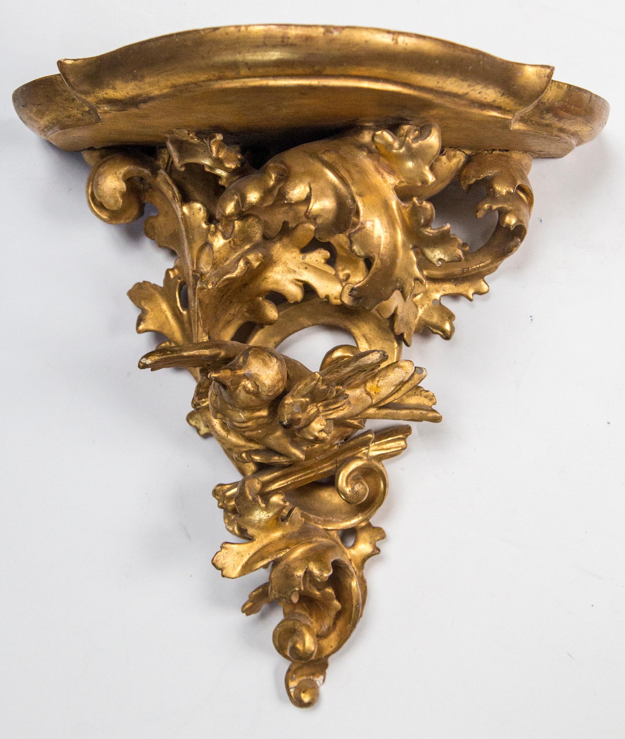 In the Rococo style of the late 18th, early 19th century. Each with a central figure of a bird, wings out, beak open and sitting within its nest. They are surrounded by foliate scrolls and leaves. One bird faces left while the other faces to the