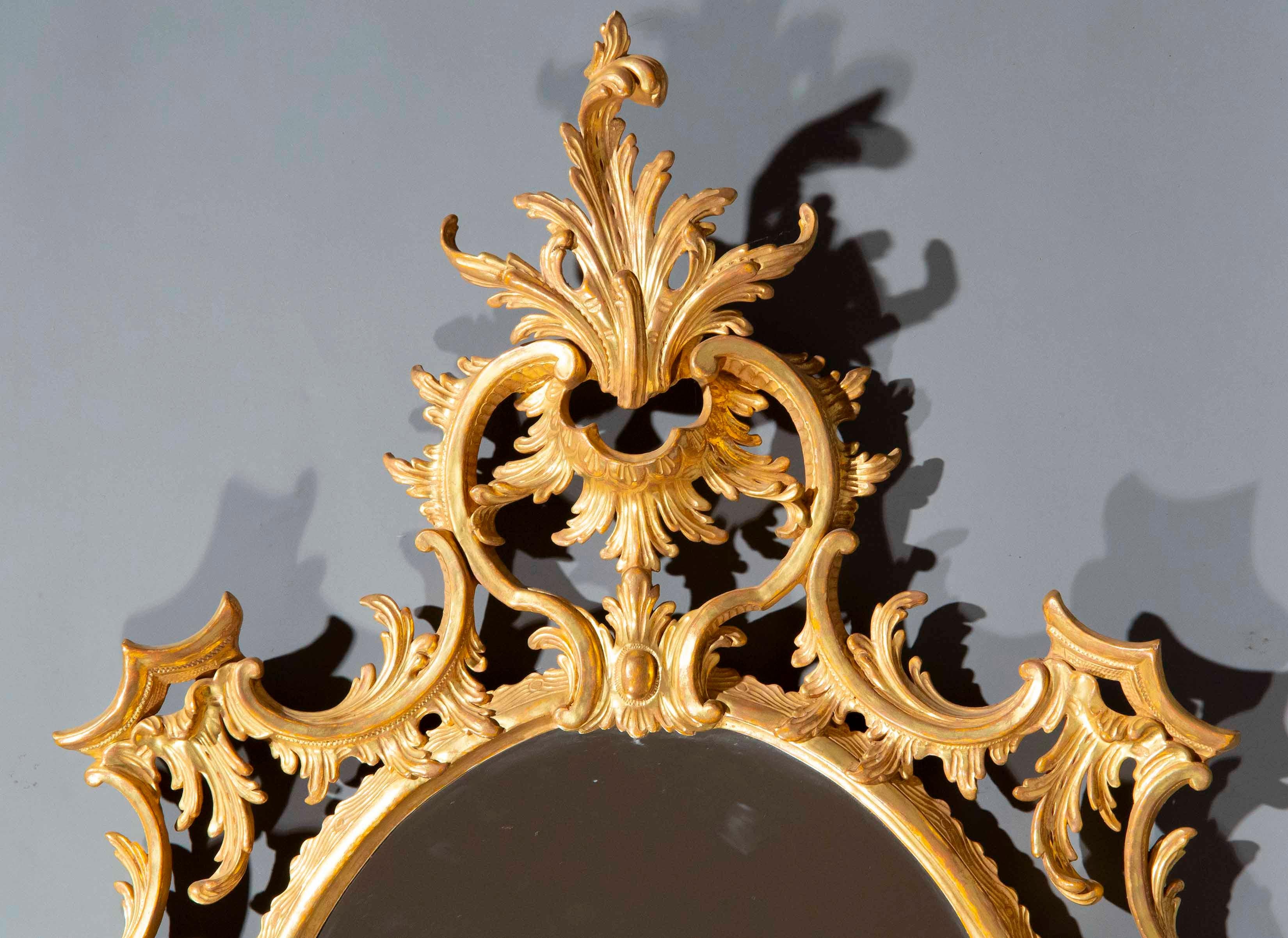 Un'elegante e rara coppia di specchi da parete con elaborate cornici in legno dorato intagliato su disegni del famoso ebanista e designer del XVIII secolo Thomas Chippendale. Inglese, XX secolo. Un modello molto ambito e ricercato.

Perché ci