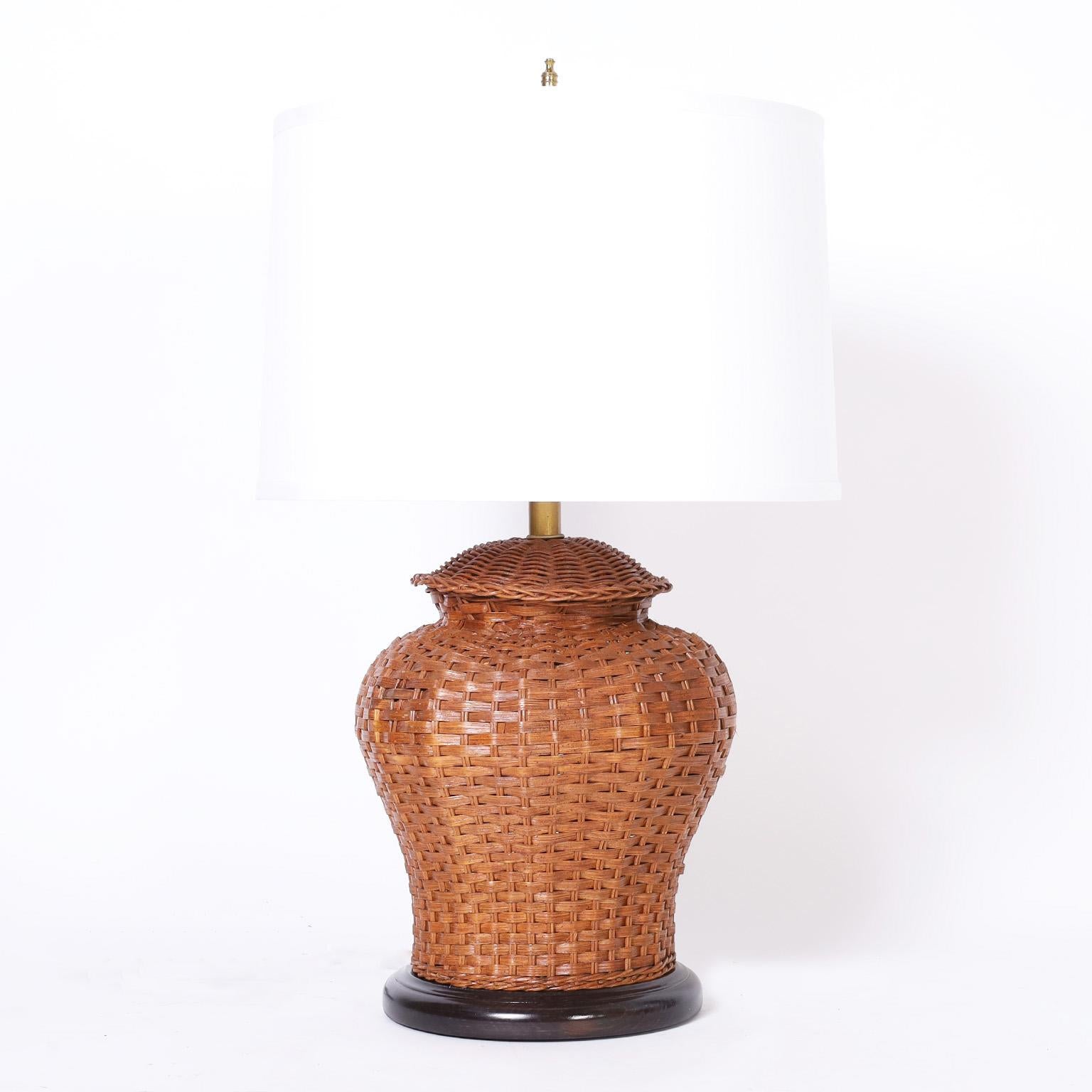 Asian modern style table lamps crafted in woven reed in a classic ginger jar form on lacquered wood bases.
