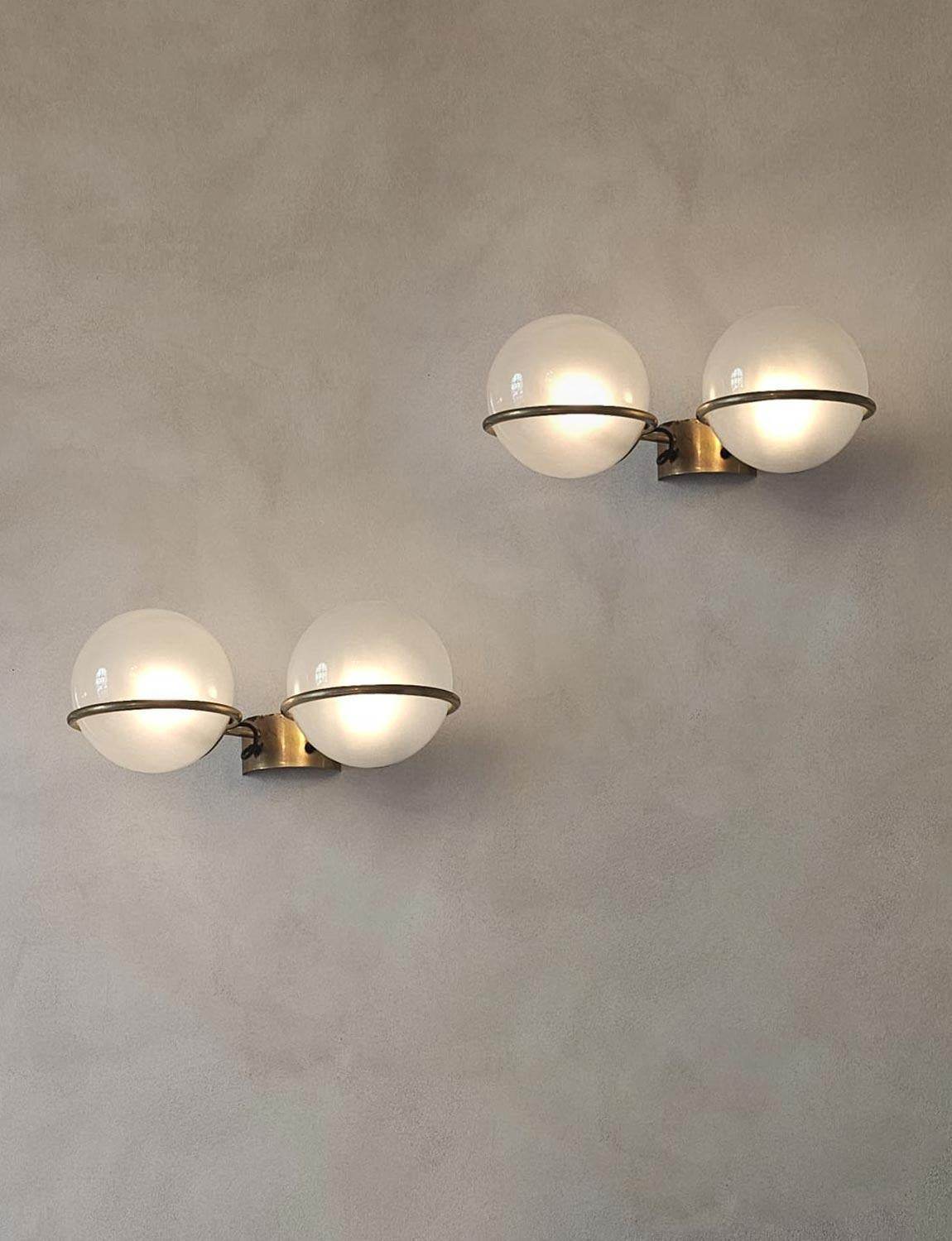 A pair 1950s Italian wall lights by Gino Sarfatti. Each light has two frosted glass balls suspended on brass hoops and with a brass wall fitting. They are stunning and give a most beautiful glow as can be seen in the photographs. 