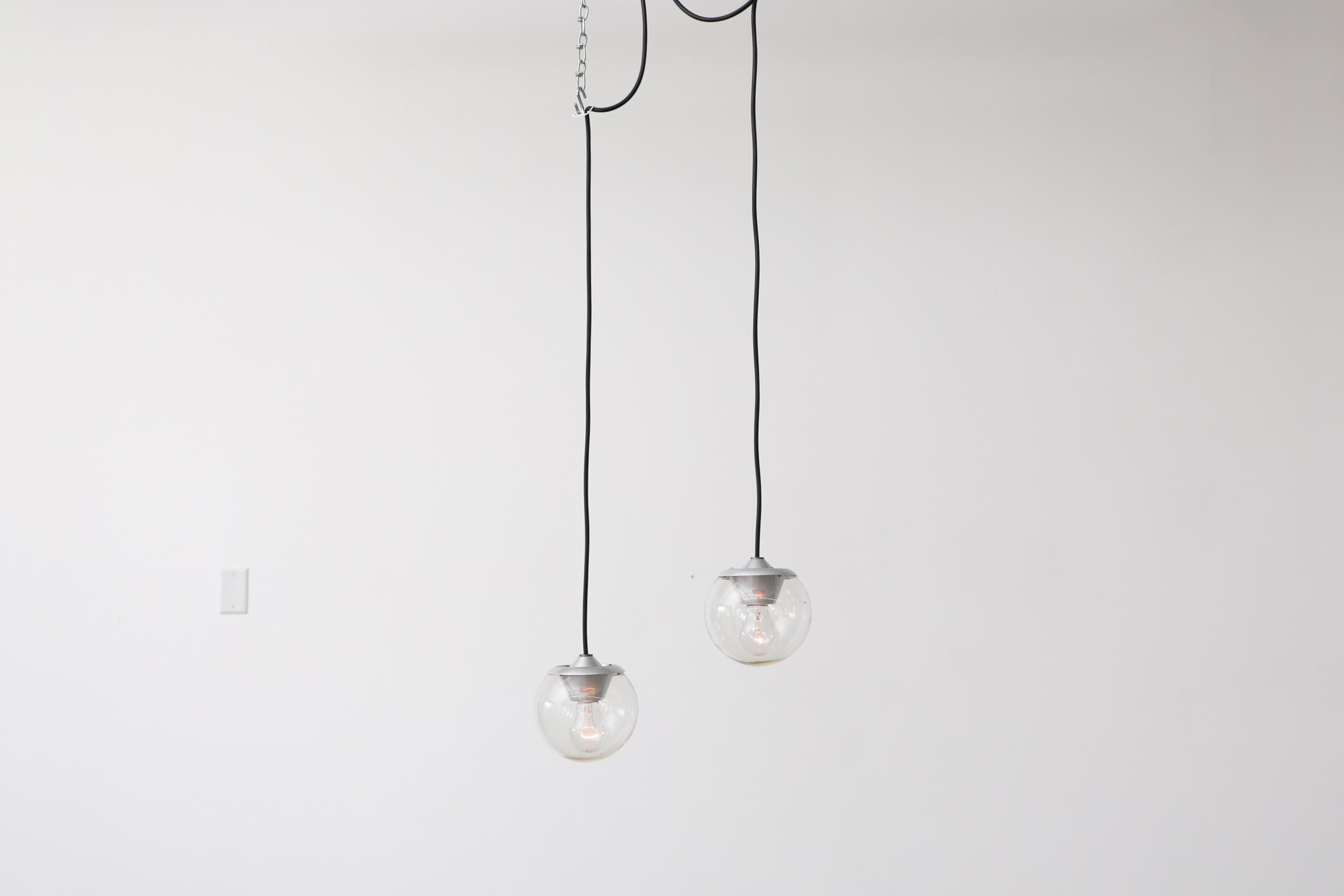 Pair of Gino Sarfatti Pendants Model 2095/1 by Arteluce, Italy, 1958. Blown glass pendant lights with clear glass globe shades, aluminum hardware and long cords. These pendants do not have canopies. In original condition with visible wear,