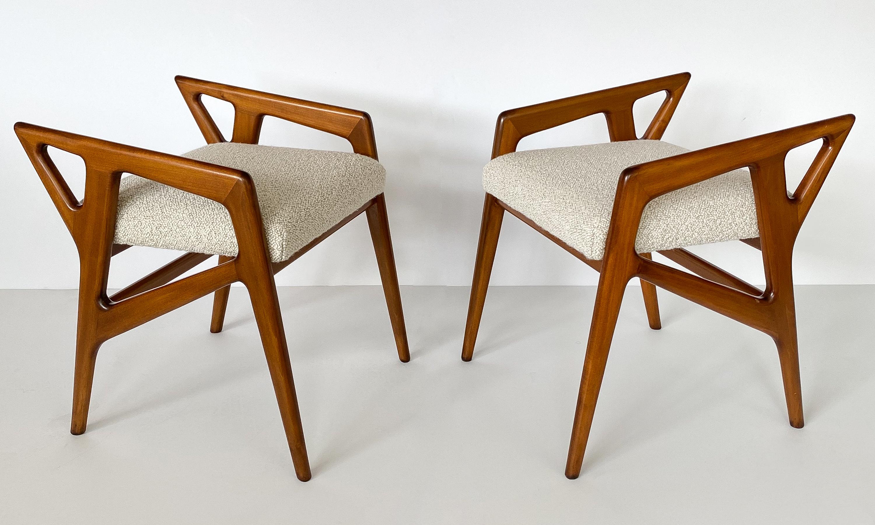 Pair of sculptural carved solid Italian walnut stools by Gio Ponti, circa 1950s. Newly upholstered in a two-toned taupe and cream textural bouclé fabric by Pierre Frey. Angular walnut frames are newly refinished. New cushions. A fabric swatch is