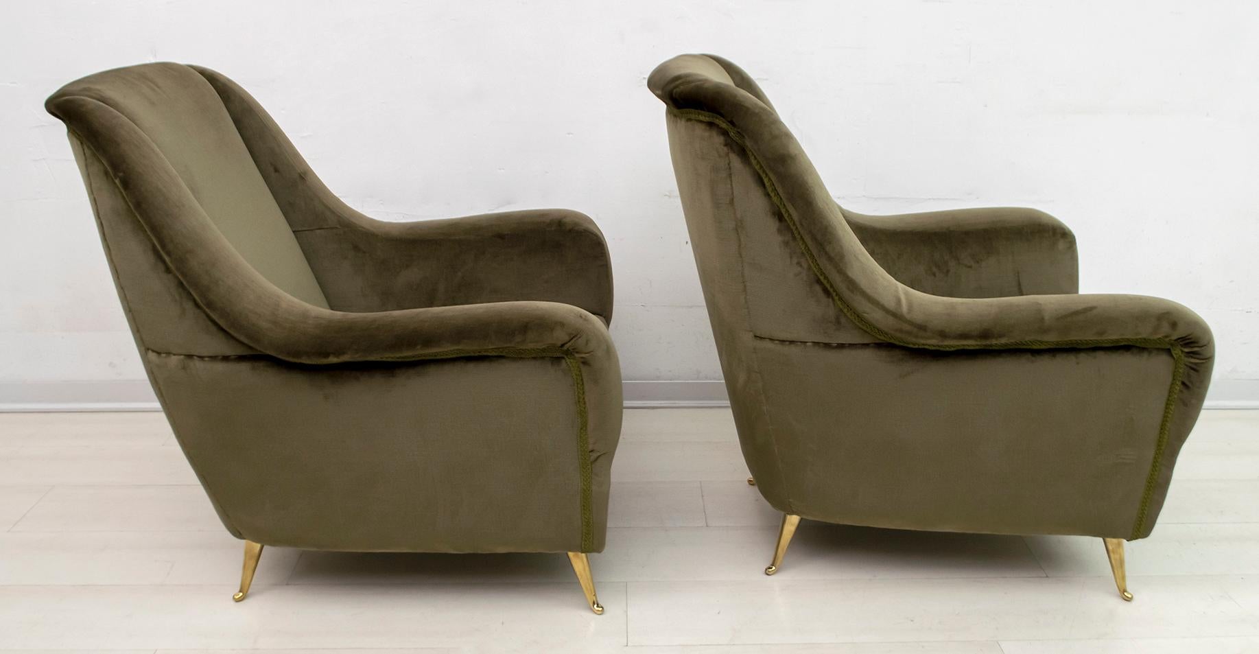 Elegant and splendid pair of Mid-Century Modern armchairs with high back and brass feet, attributed to Gio Ponti, 1950 for ISA Editions, Bergamo. Sculpted profile, refined lines, sensual and deep comfort. The chairs have their original dark green