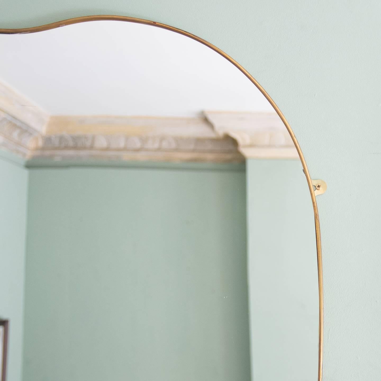 A pair of Italian brass framed mirrors in the style of Gio Ponti, dating to the 1950s.