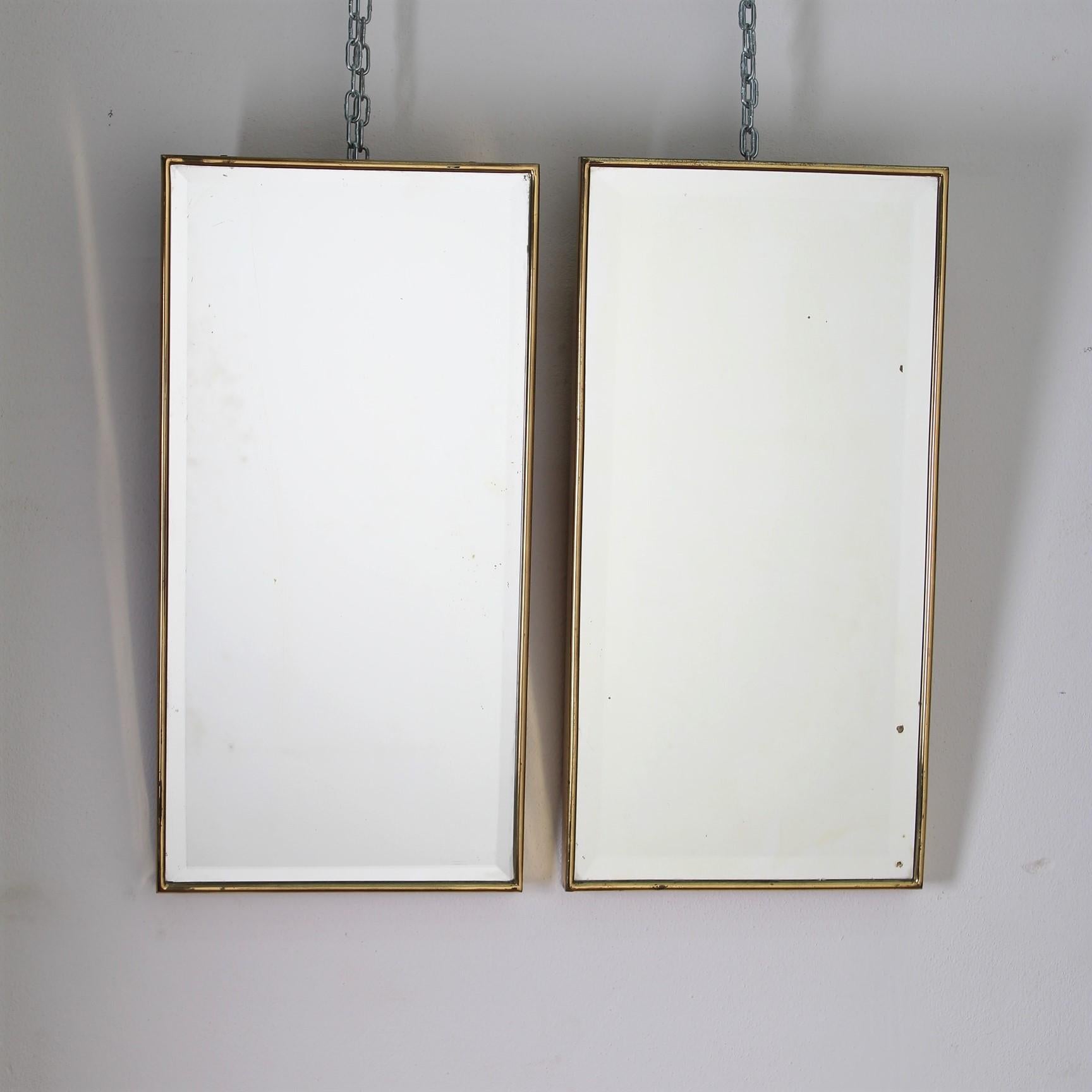 A large pair midcentury Italian wall mirrors with a brass frame from the circa 1950s. The mirrors have a rectangular form, bevelled at the edges, classically elegant, and distinct in a modern Gio Ponti style.
Wear consistent with age and use