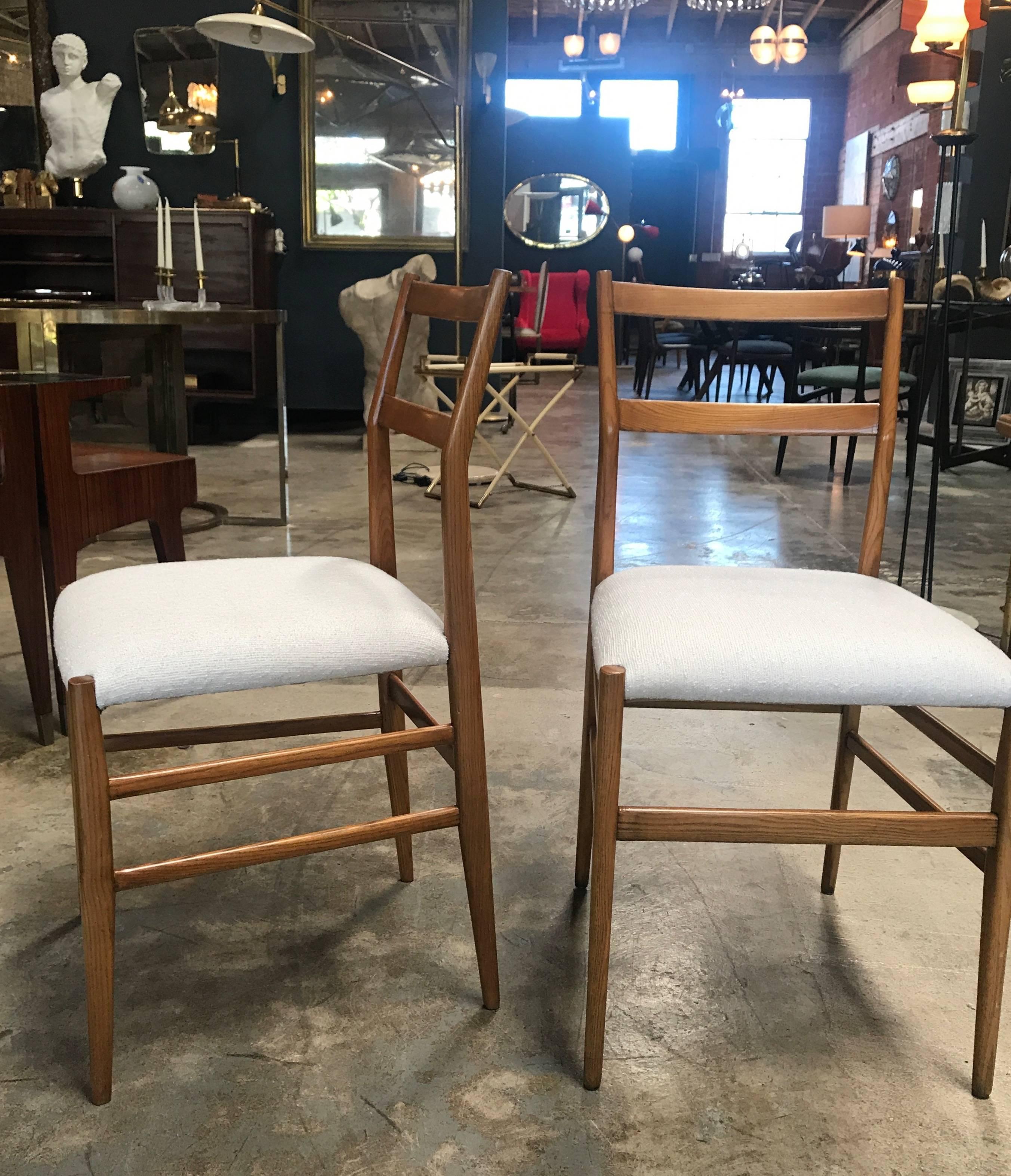 Pair of iconic Gio Ponti Superleggera dining chairs with upholstered fabric.