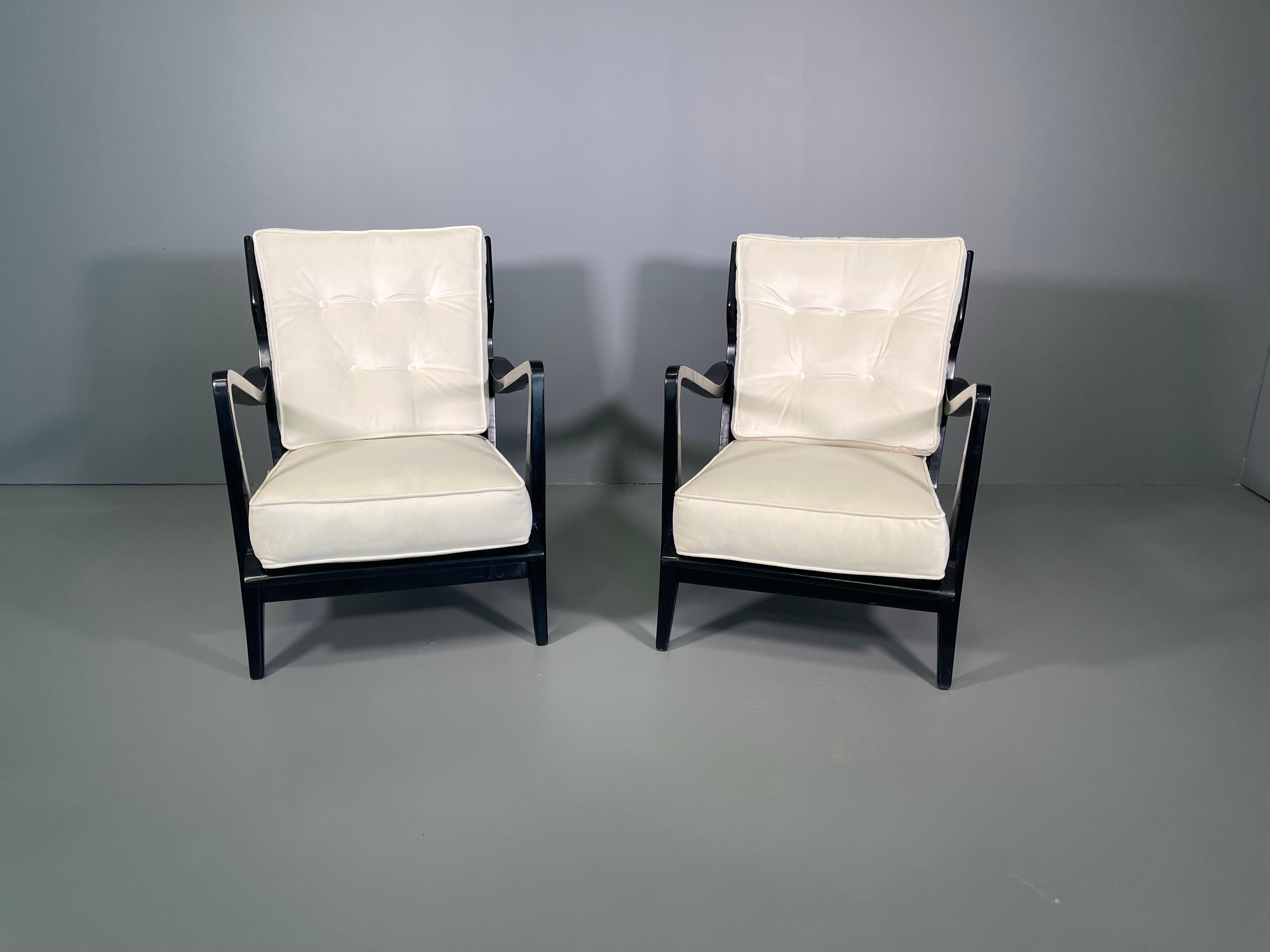A pair of armchairs, model 516, designed by Gio Ponti and edited by Cassina in the 1950s. Walnut wood ebanized and fabric. Upwards rising arms and vertical open slats on the back. Each chair has at the reverse a label stating :