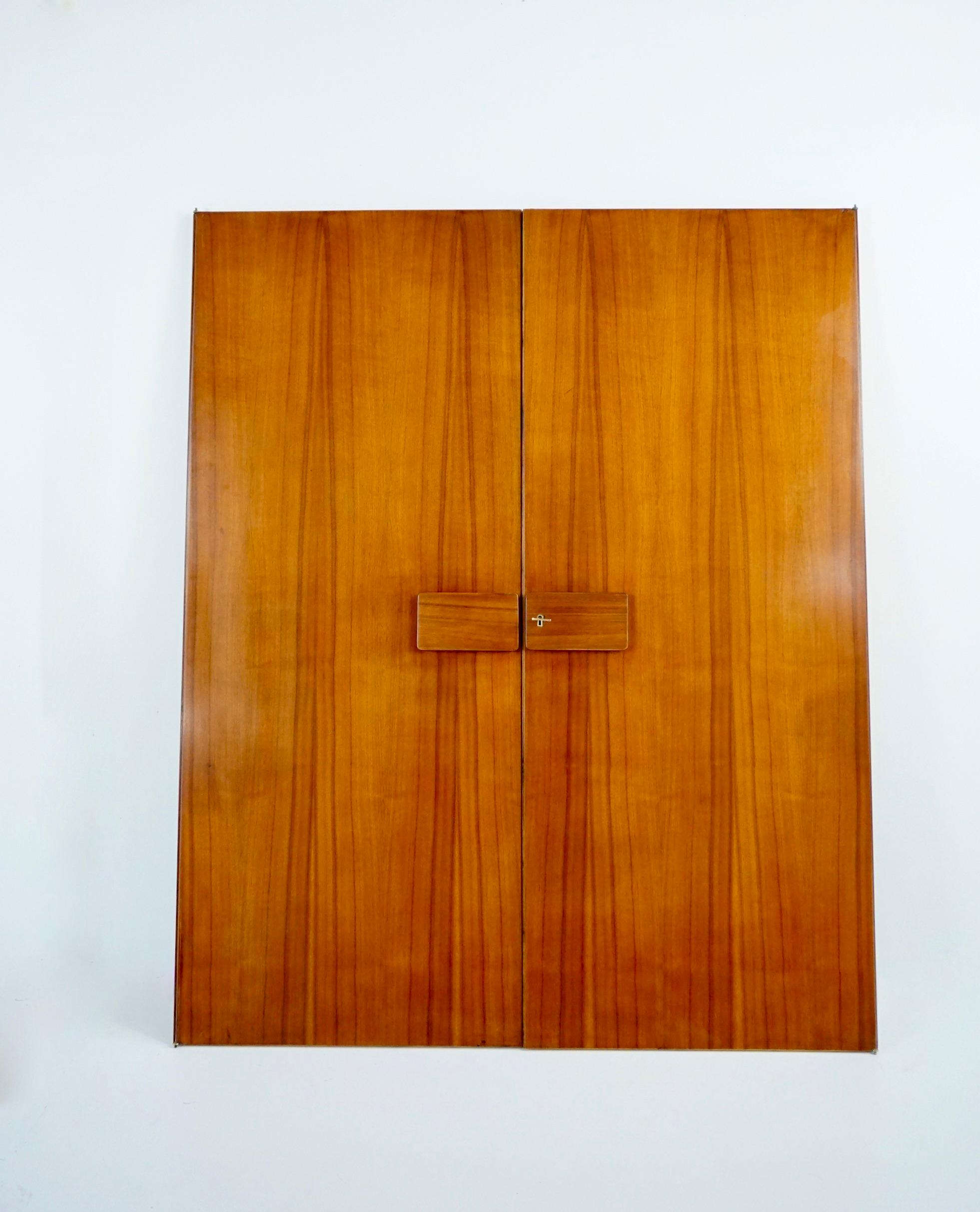 Rare pair of Gio Ponti wardrobe doors, 1955
from the furniture of the Hotel Royal, Naples
manufactured by Giordano Chiesa and produced by Dassi Lissone
2 mirrors on the verso
walnut, brass details and mirrors
original brass key with engraved 