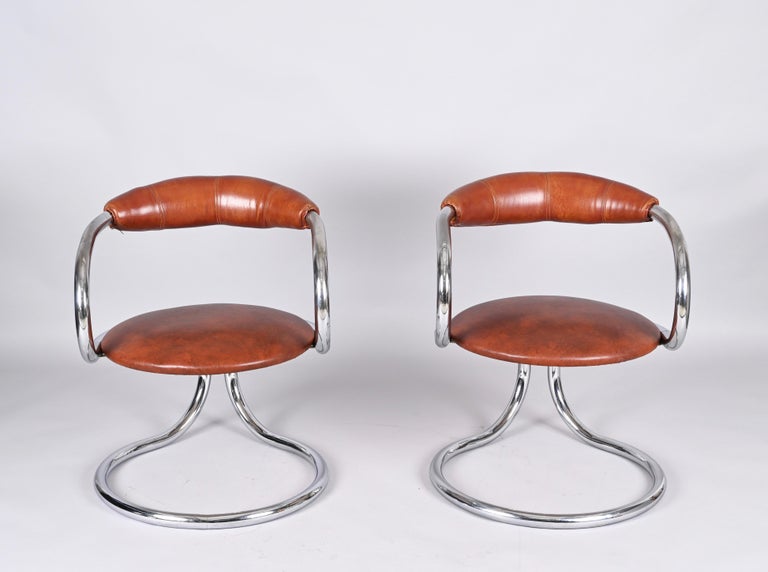 Stunning set of two chromed steel and brown leather chairs. Giotto Stoppino designed these chairs during the 1970s in Italy.

The Chairs have a wonderful tubular structure in chromed steel with a rounded, symmetrical shape. 
Both the seating and