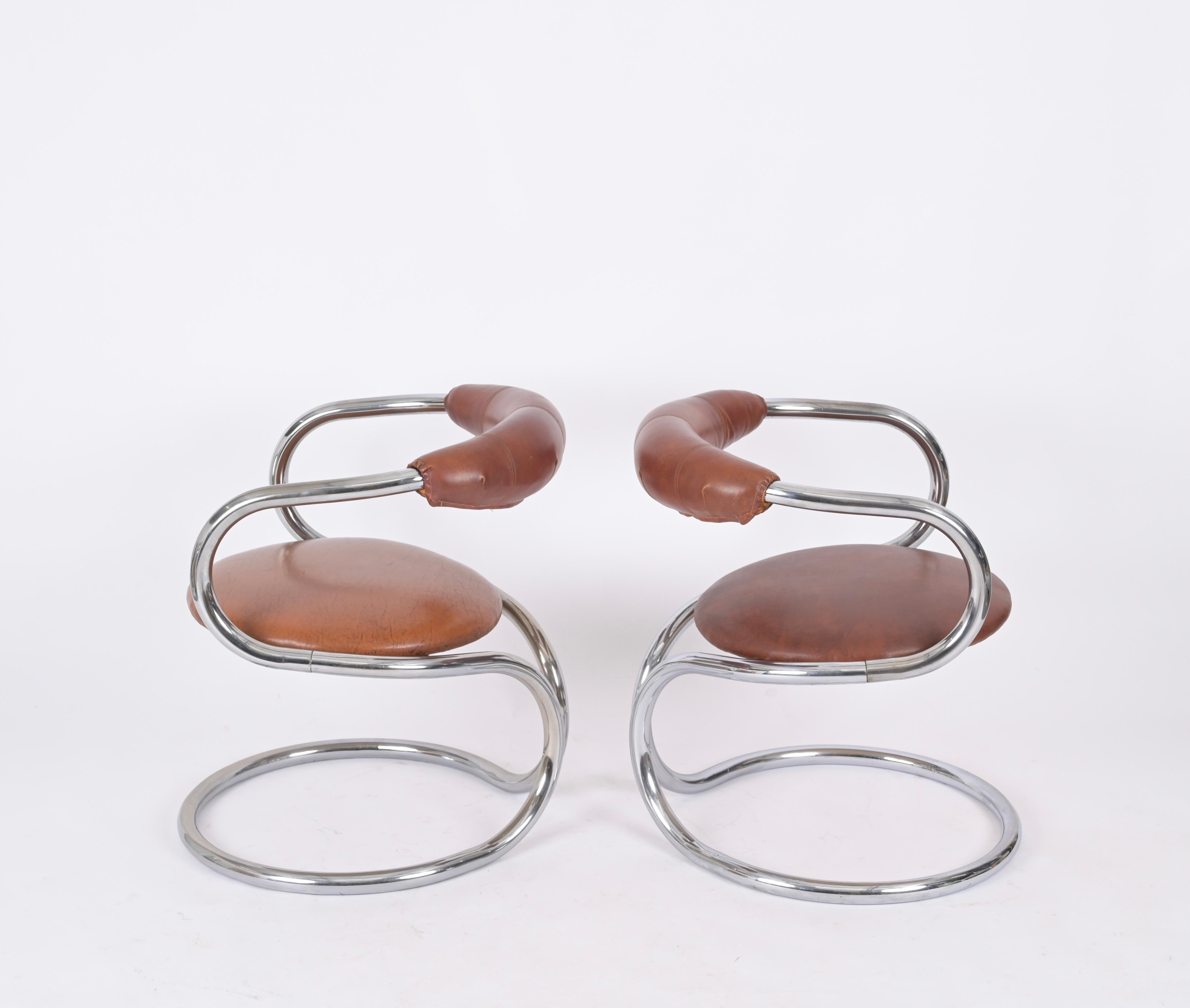 Merveilleux ensemble de deux chaises en acier chromé et cuir brun. Giotto Stoppino a conçu ces chaises dans les années 1970 en Italie.

Ces chaises élégantes ont une magnifique structure tubulaire en acier chromé avec une forme arrondie et