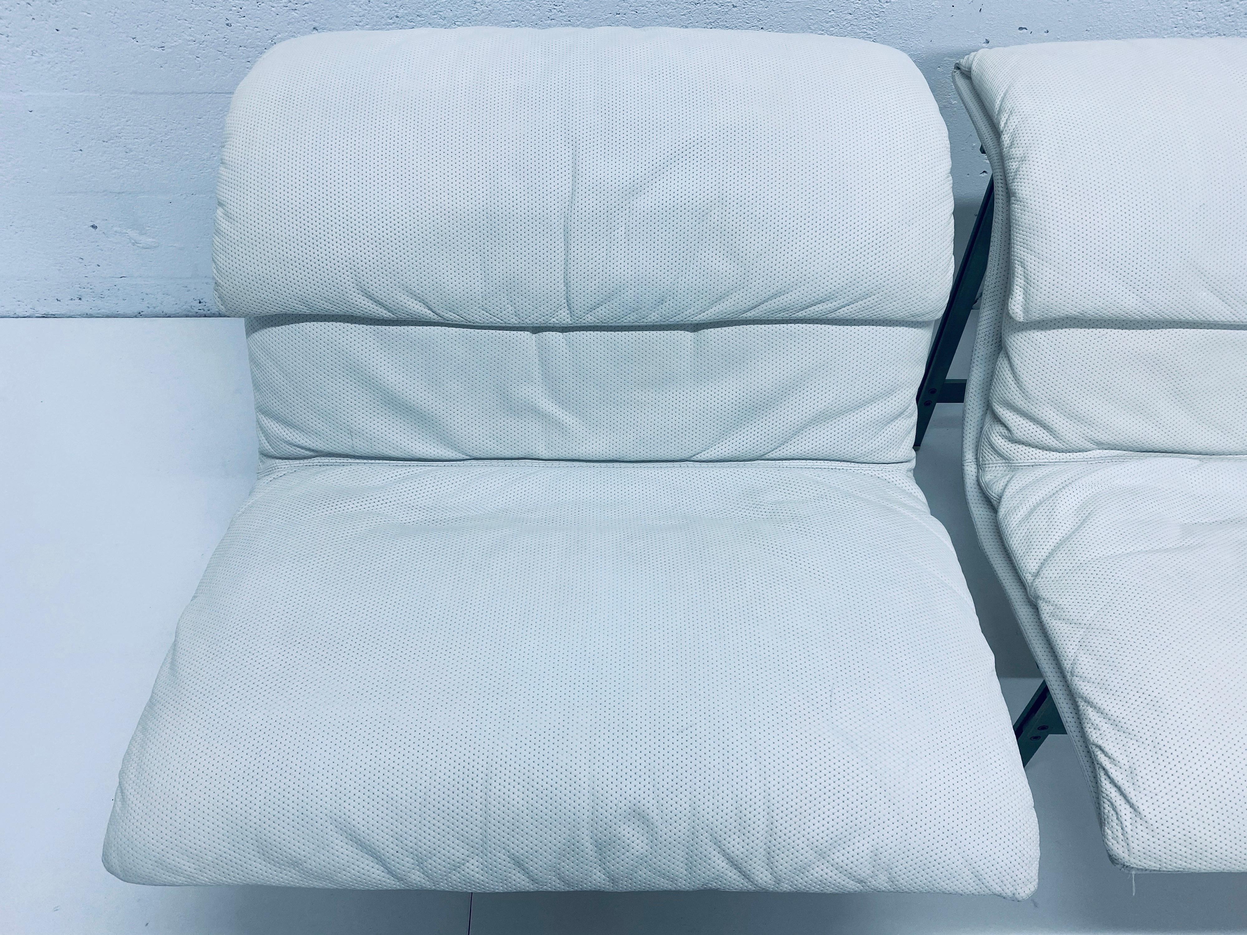 Two perforated white leather Onda wave lounge chairs with original pillows by Giovanni Offredi for Saporiti Italia. Maintains original label.

Leather has been professionally cleaned, whitened and conditioned to bring the leather back as close to
