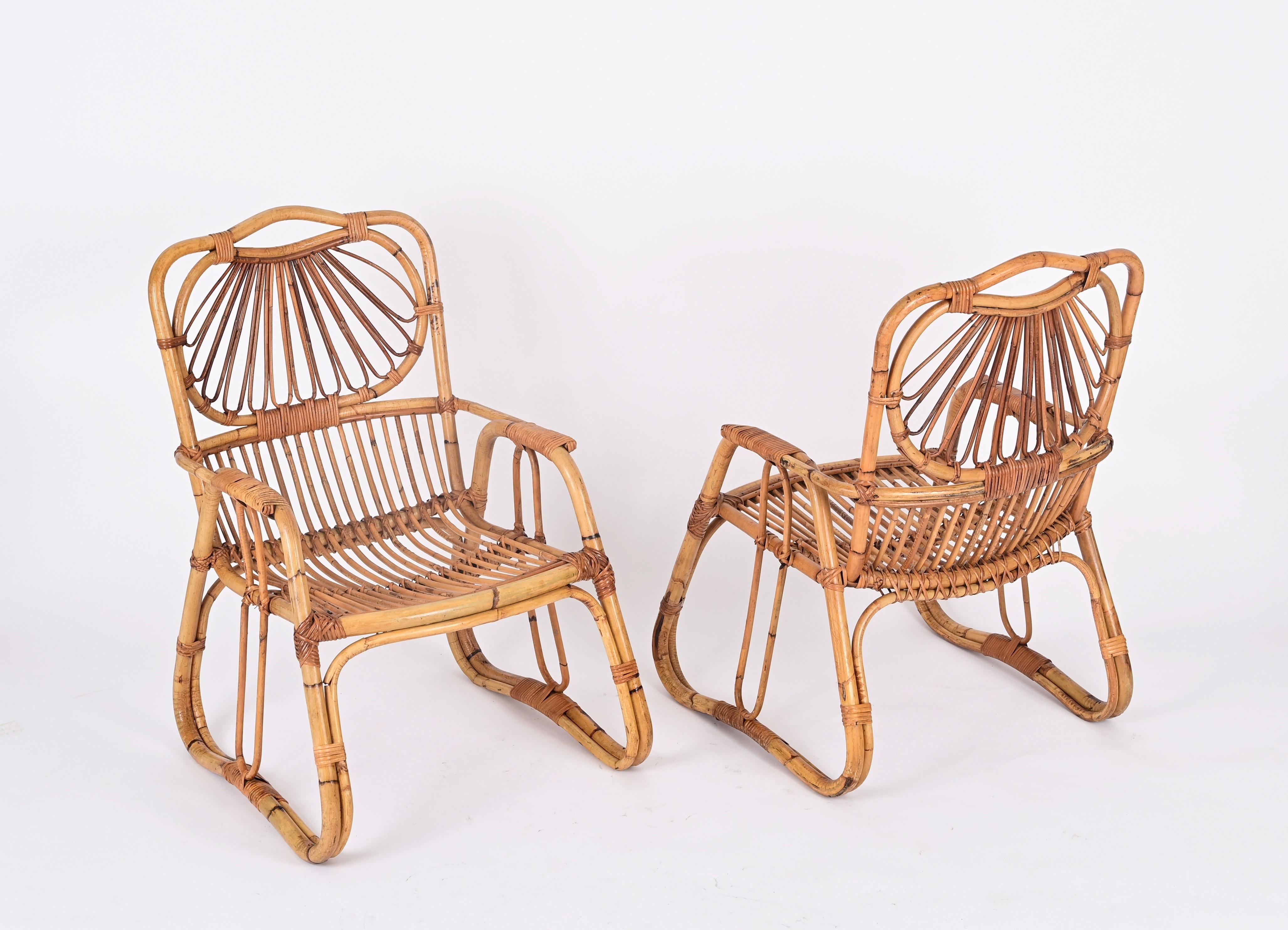 Stunning pair of Mid-Century Italian armchairs made in a beautiful combination of curved rattan and hand-woven wicker. This charming French Riviera style armchairs are attributed to Giovanni Travasa and were made in Italy during the 1960s.  

Fully