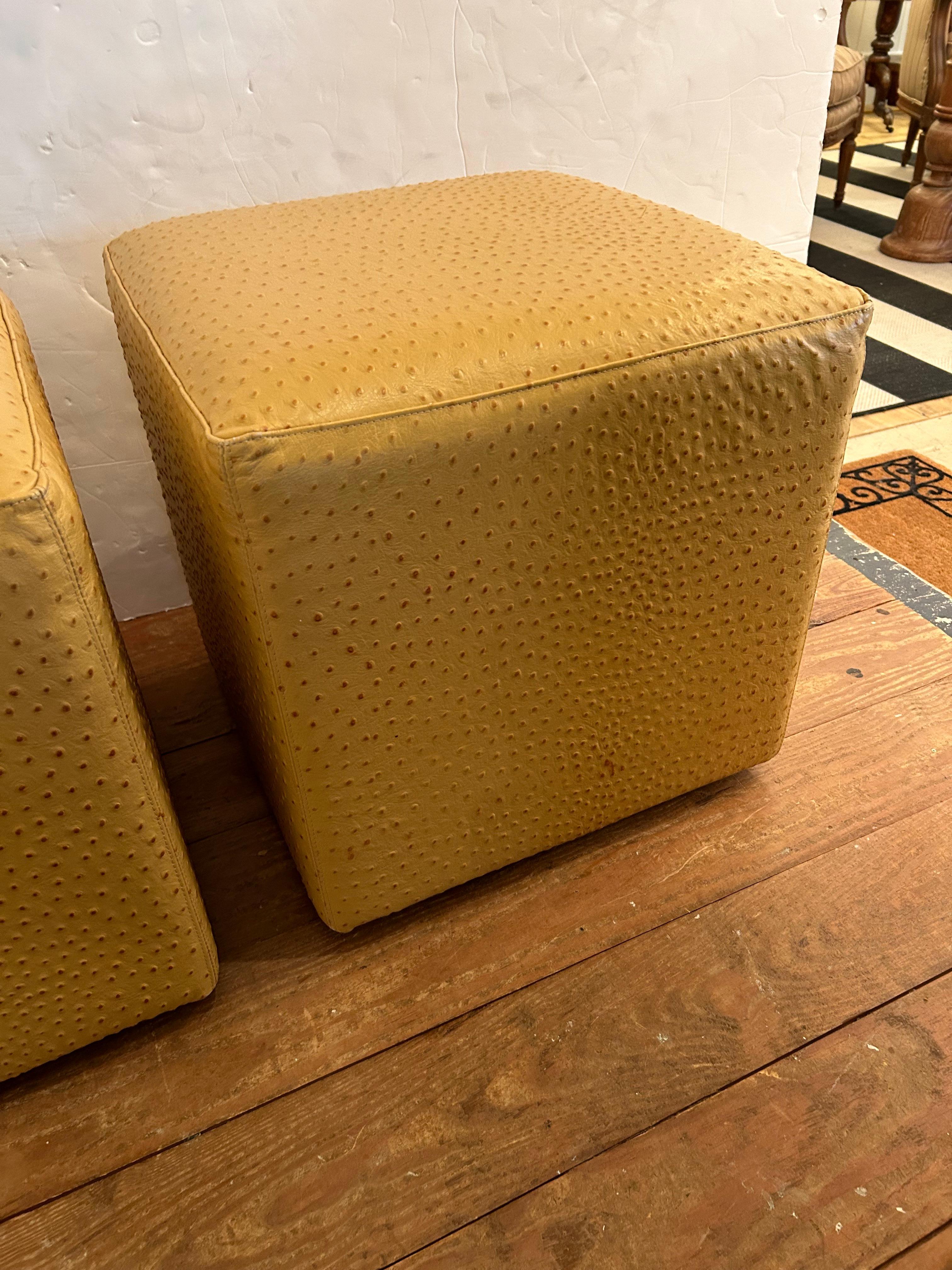 Glamorous pair of cube shaped faux ostrich ottomans in a beigy gold color.  Makes great floating extra seating.