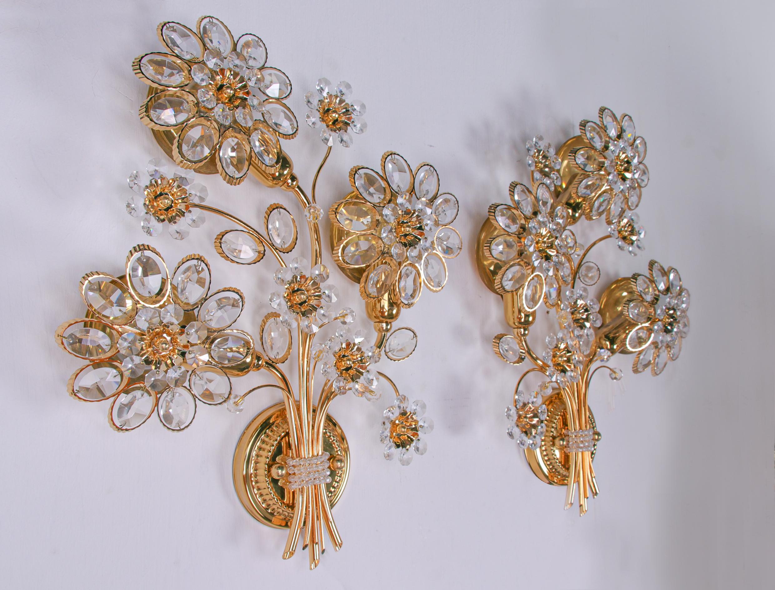 Elegant wall sconces with a gold-plated brass frame and Swarovski crystals. These lamps have an incomparable unique character. A touch of luxury fills the room. 

Manufacturer: Palwa, Palme & Walter., Germany. 
Measures: diameter 12.2