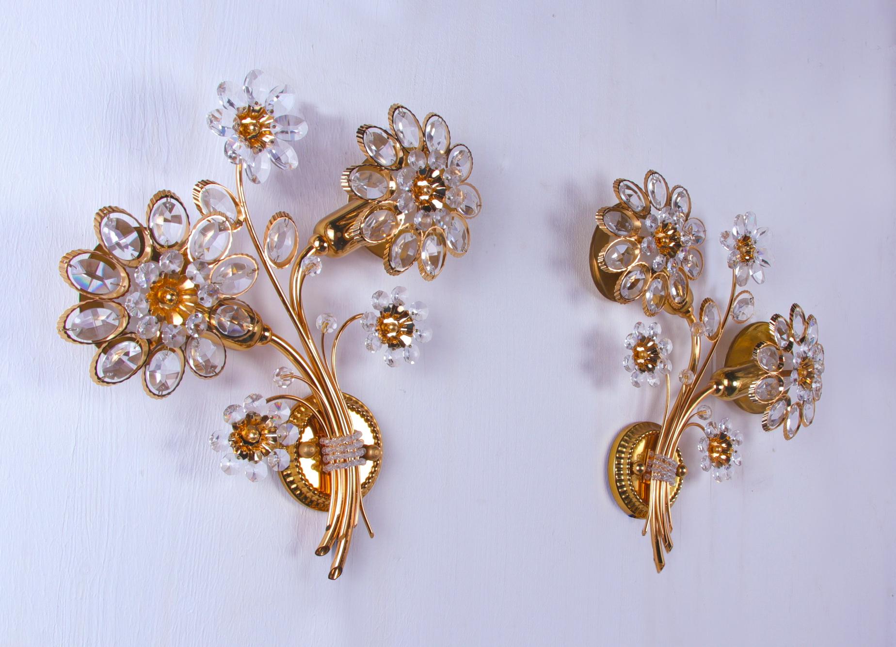 Elegant wall sconces with a gold-plated brass frame and Swarovski crystals. These lamps have an incomparable unique character. A touch of luxury fills the room. 

Manufacturer: Palwa, Palme & Walter., Germany. 
Measures: diameter 12.2