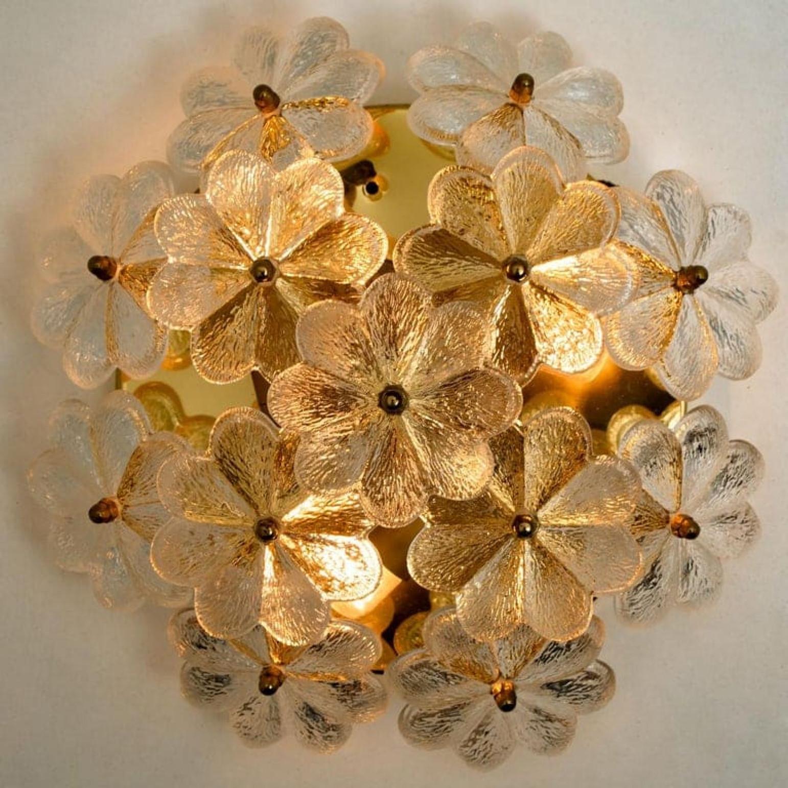 Dieses Paar skulpturaler Wandleuchter mit dem Design eines Blumenstraußes aus strukturiertem Glas stammt von der historischen Leuchtenfirma Ernst Palme. Jede Leuchte hat dreizehn Glasschirme. Blumenförmig.

Jeder Blütenschirm aus Klarglas hat