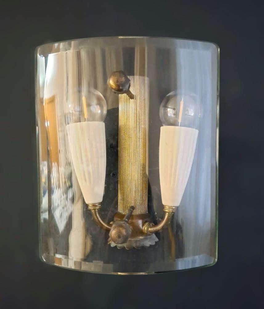 Applique murale classique italienne vintage avec un diffuseur en verre clair biseauté et incurvé monté sur une monture en laiton patiné / Fabriquée en Italie dans le style de Fontana Arte, vers les années 1950.
Dimensions : largeur 5,5 pouces,