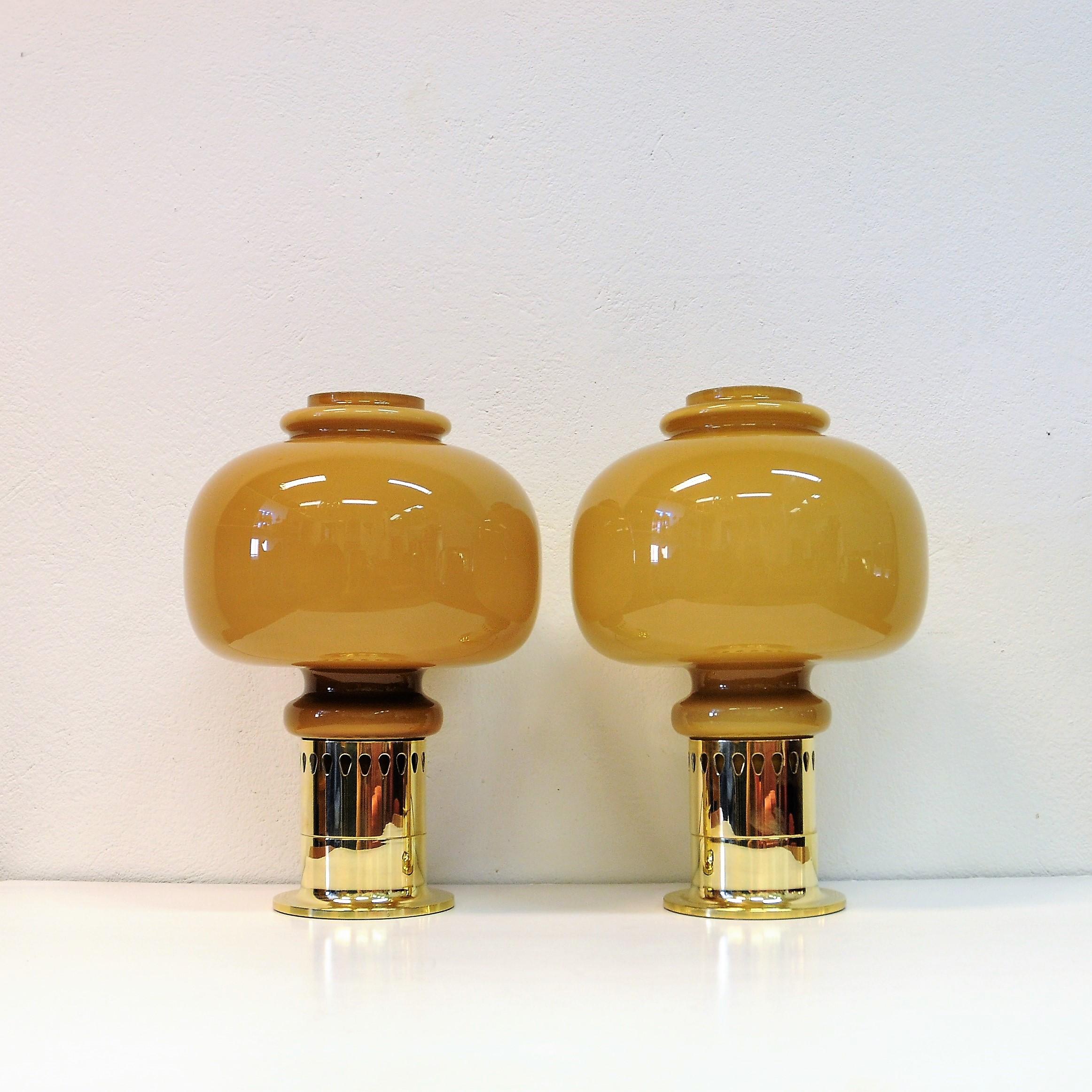 A pair of Swedish glass and brass table Lamps with brown big special shaped lampshades designed by Hans-Agne Jakobsson, Sweden 1960's. H: 39 cm.
Nice lamp bases of brass with decor as a board around. Measures: Total height of lamps about: 39 cm.