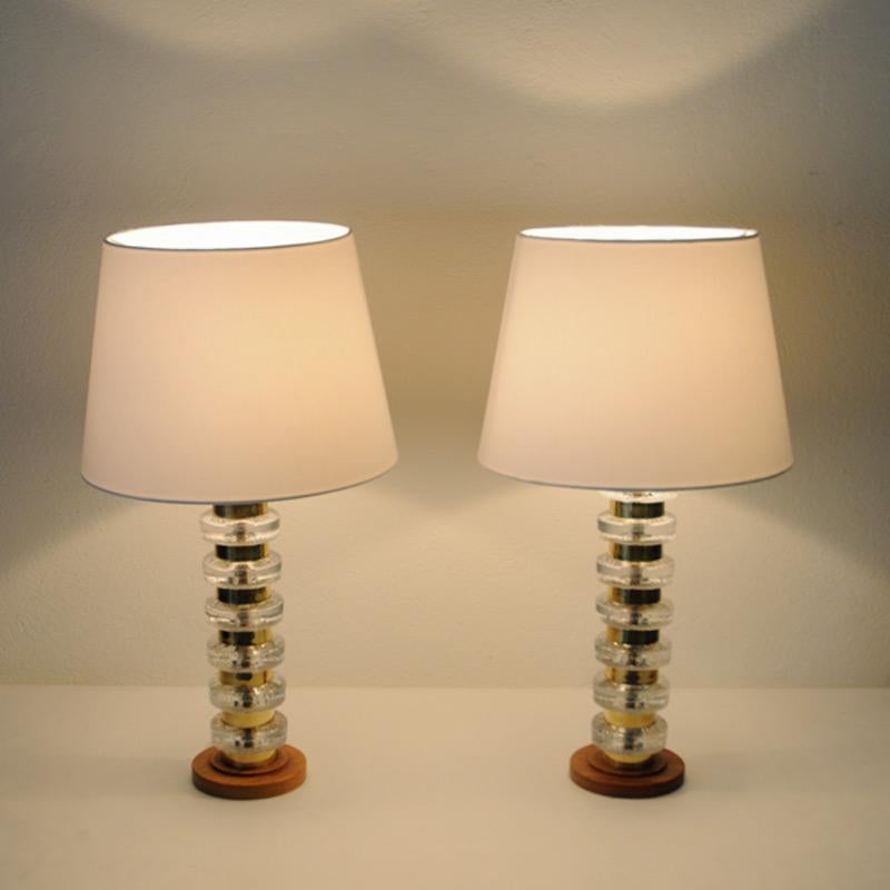 Nice pair of Swedish table lamps with decorative poles of layers in glass and brass sections all the way from bottom to top. Measures: Total height about: 42 cm. Lamp foot 13 cm D. Lampshades not included.