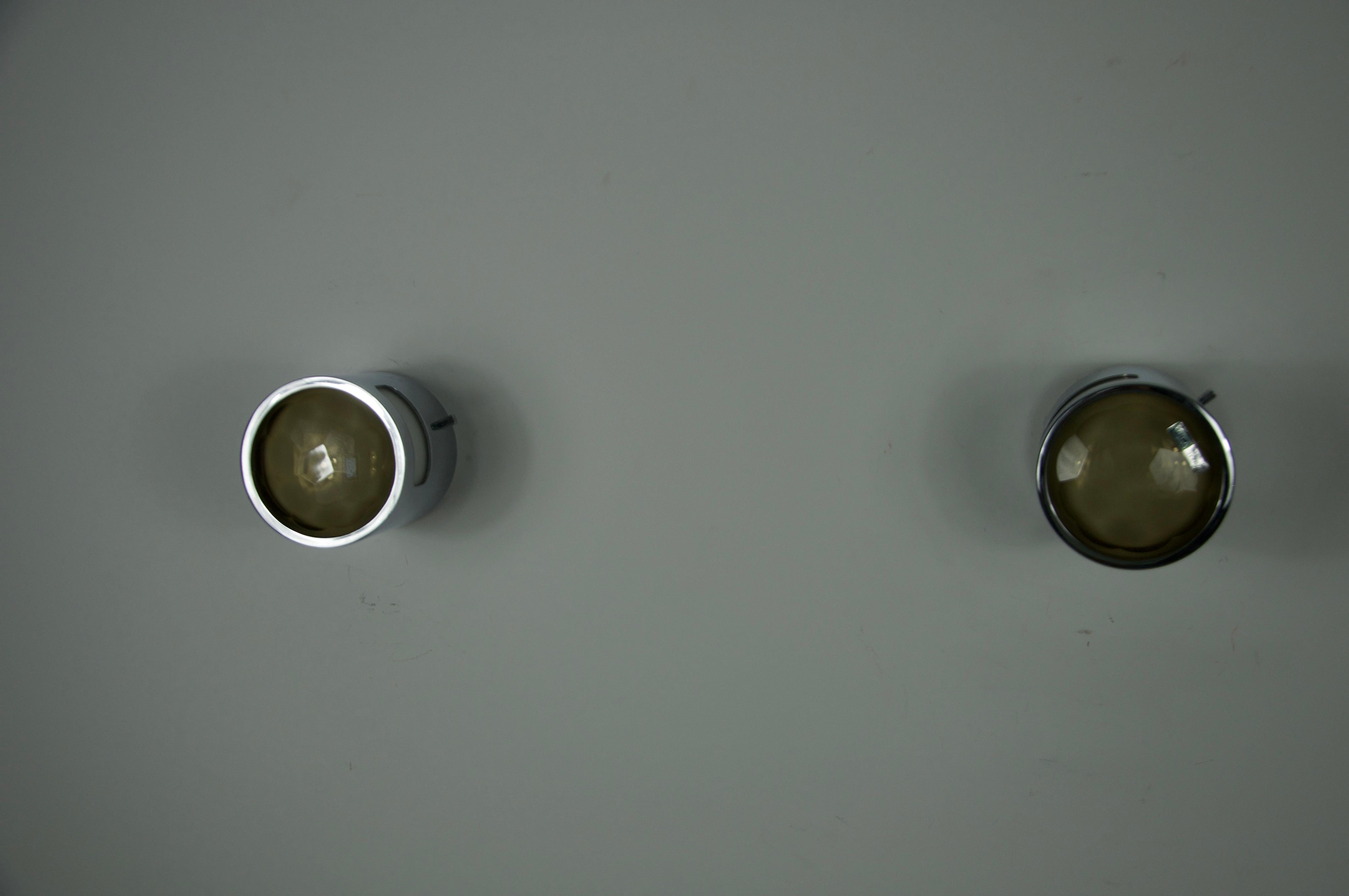 Questa straordinaria coppia di lampade da parete è stata progettata e prodotta da Veca in Italia negli anni Sessanta. Combinando il metallo lucido con diffusori in vetro scultoreo, catturano perfettamente l'eleganza del design italiano della metà