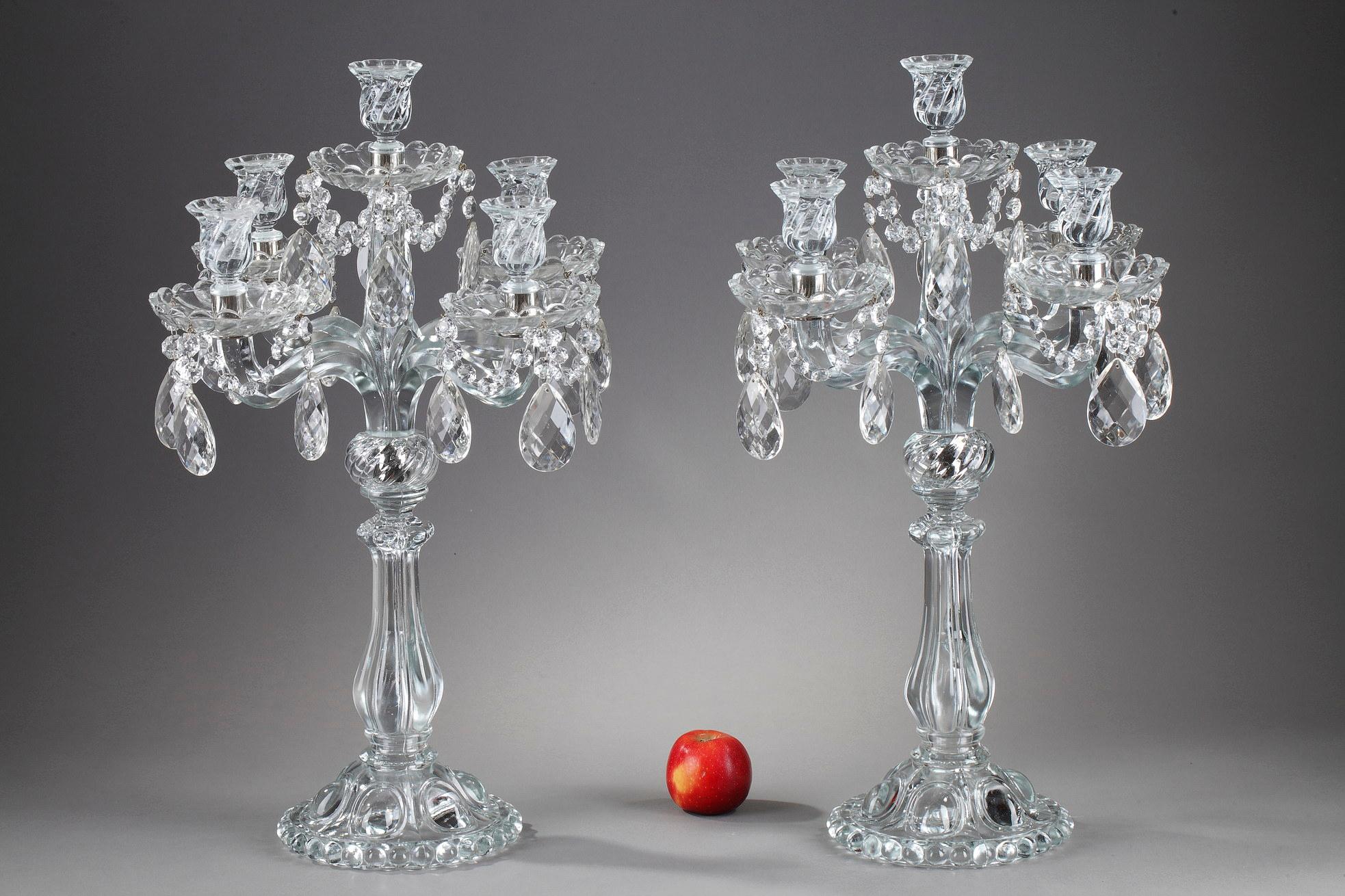 Pair of five-light candelabras in glass and crystal. It is composed of four arms and an upper post. The shafts are ringed and the feet decorated with gadroons. The ensemble is decorated with crystal pendants. 

These candelabras are similar in