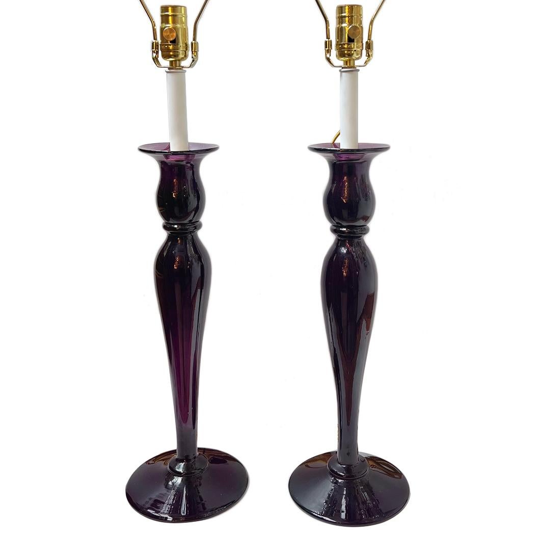 A pair of electrified circa 1950s French amethyst glass candlestick lamps.

Measurements:
Height of body: 21.75?
Height to shade rest:31.5?
Diameter: 6.5?