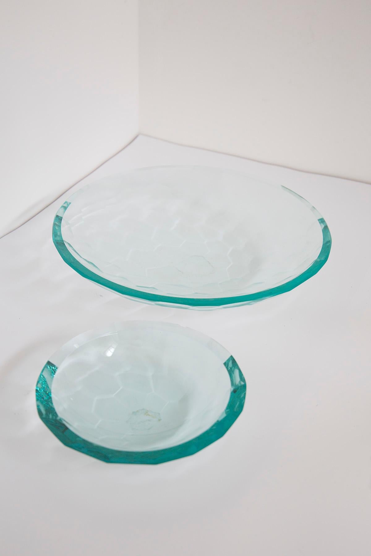 Élégante paire de centres de table réalisés en verre épais selon une technique de tamponnage à la main. La paire est dans le style de la grande manufacture Fontana Arte réalisée dans les années 1980.
Dans la paire, nous trouvons deux bols, l'un plus