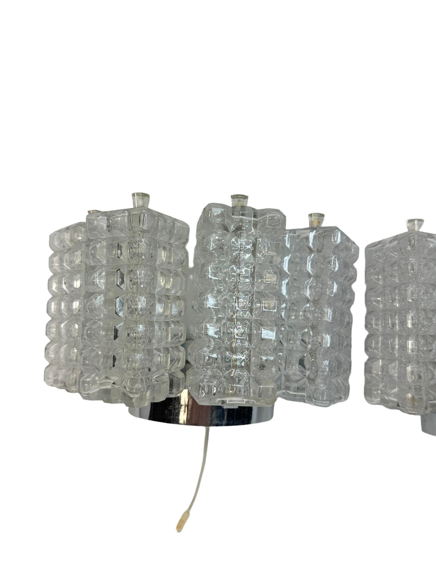 A beautiful pair of Austrian sconces by Austrolux, Vienna, manufactured in the mid-century, circa 1960s (late 1960s or early 1970s). Each lamp consists of a silver-colored metal frame containing chrome-plated or nickel-plated elements and large