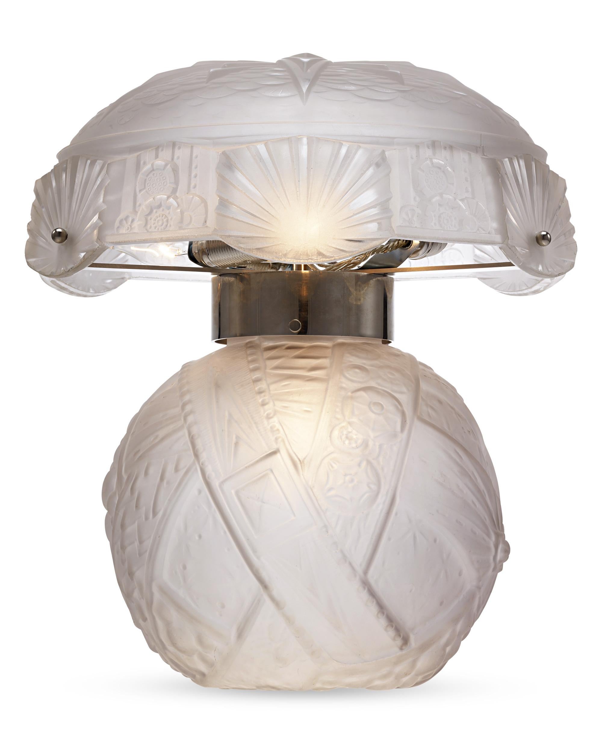 Exceptional in their artistry, these lamps from acclaimed French artisans Muller Frères cast an alluring glow reminiscent of soft moonlight. The base and shade are crafted of exquisitely etched frosted glass with stylized geometric patterns of