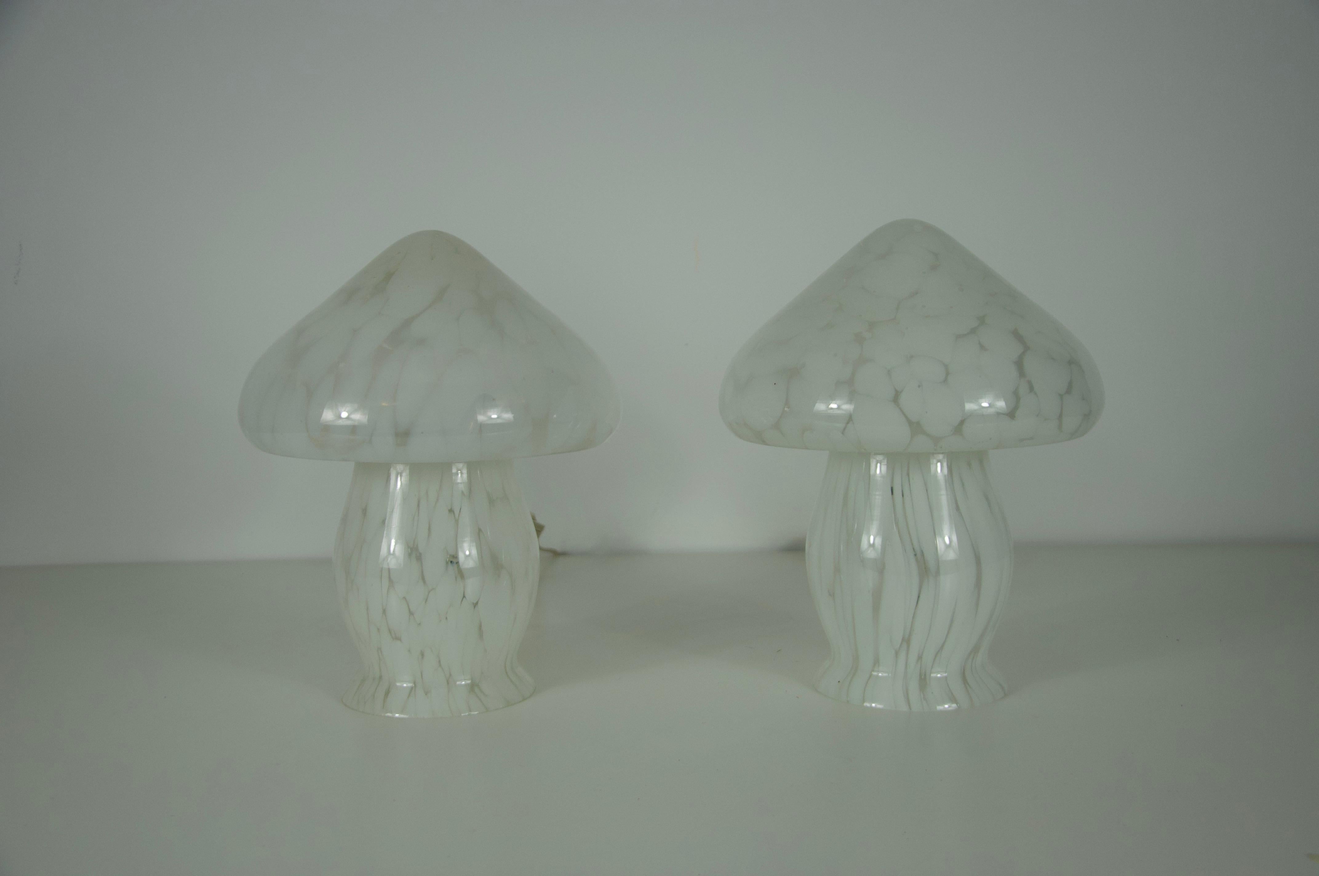 This pair of glass mushroom table lamps was produced by Limburg in Germany during the 1970s. Each lamp is crafted from hand-blown glass with a delicate white marbled pattern, giving them a soft and organic appearance. Their sculptural mushroom form