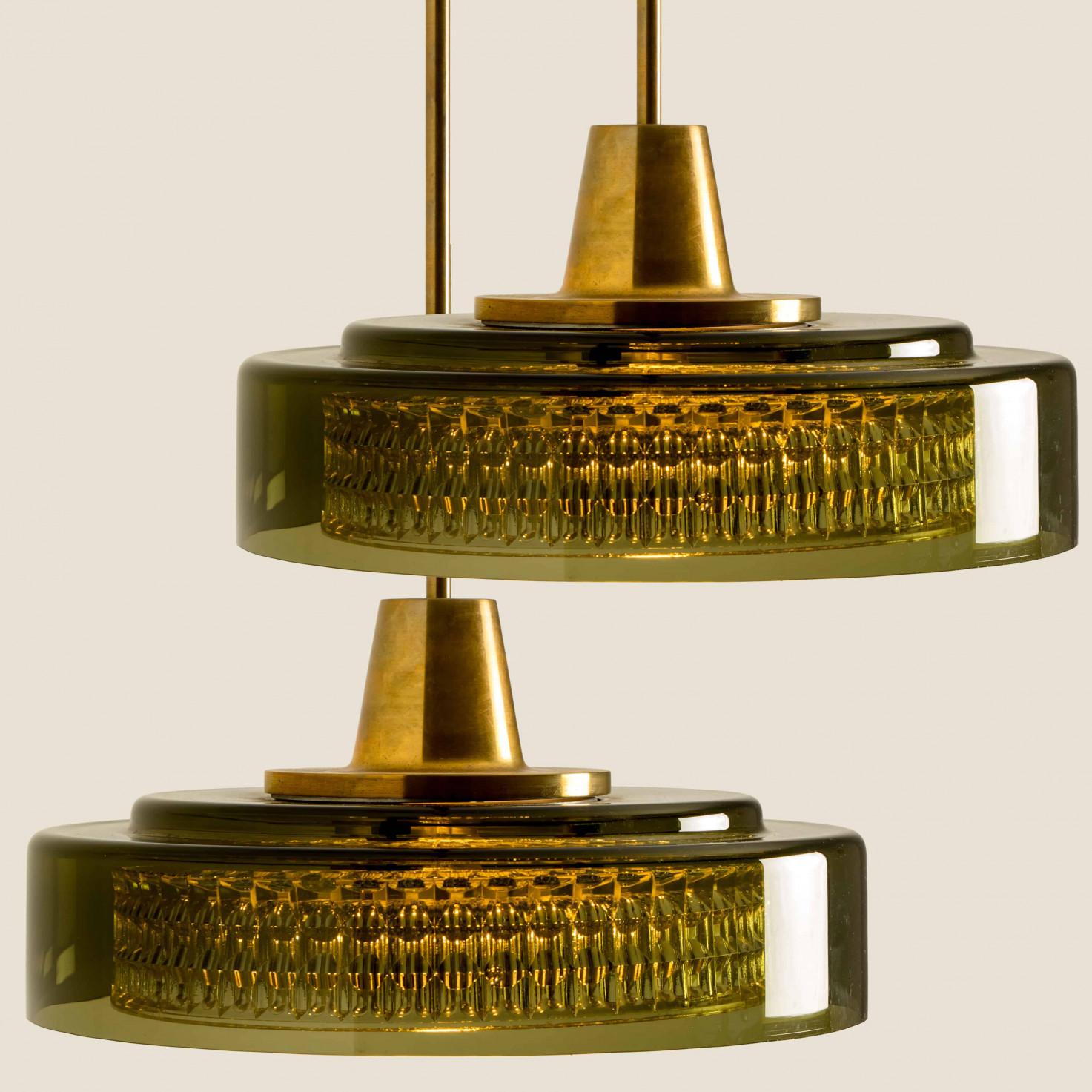 Queste lampade a sospensione in vetro verde scandinavo sono state prodotte negli anni '60 dall'iconica azienda Orrefors e disegnate da Carl Fagerlund. Il vetro esterno ha una tonalità verde chiaro, il vetro interno è trasparente e presenta una