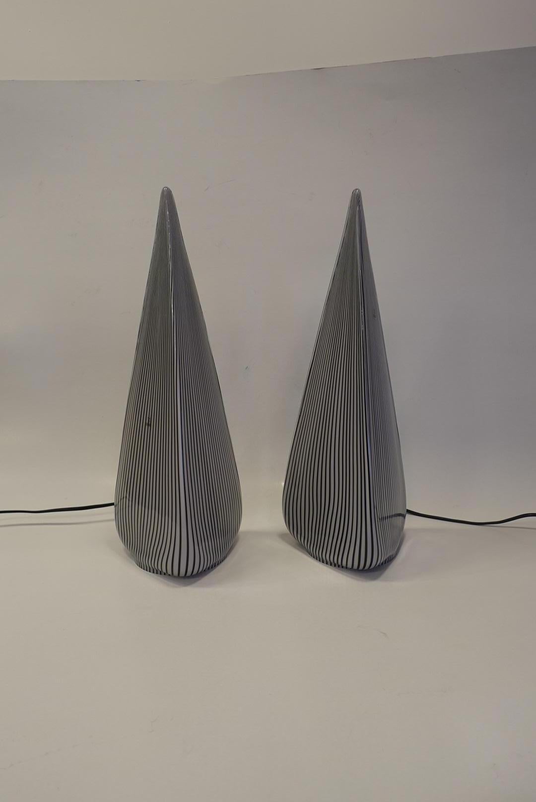 Pair of pyramid lamps in opaque white.
Brown-black candy stripes.
Signed with its original label.