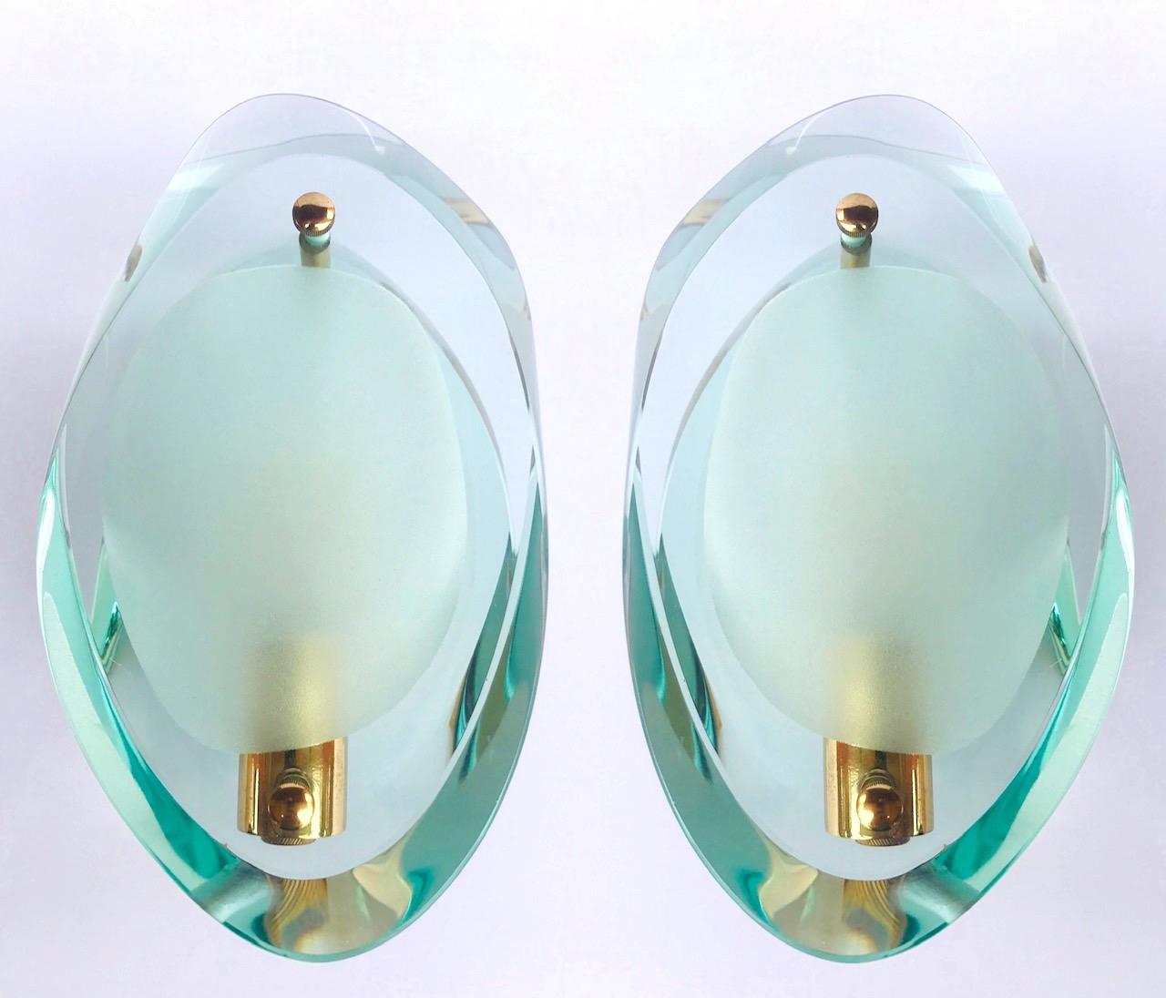 Pair of Italian Mid-Century Modern Murano glass sconces. These stunning sconces are fitted with thick beveled glass plates with organic forms and cubist design. The translucent jeweled glass has a green colored cast featuring sandblasted centers and