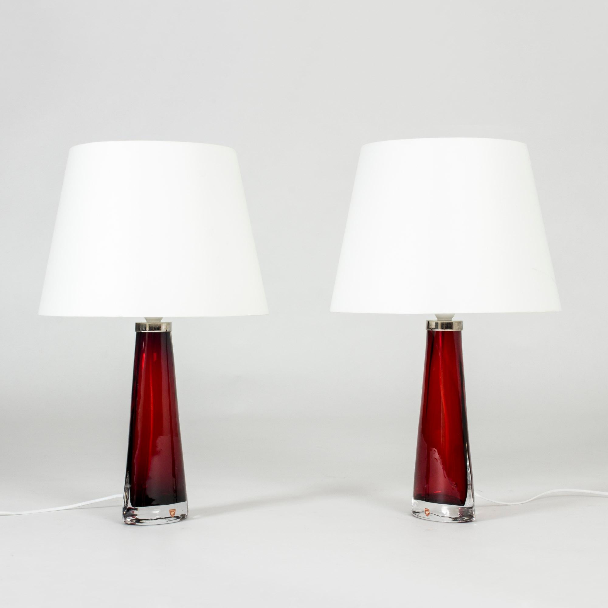 Pair of striking glass table lamps by Carl Fagerlund, made from rich red glass in a narrow conical shape, oval at the base. Beautiful translucent color, elegant design.