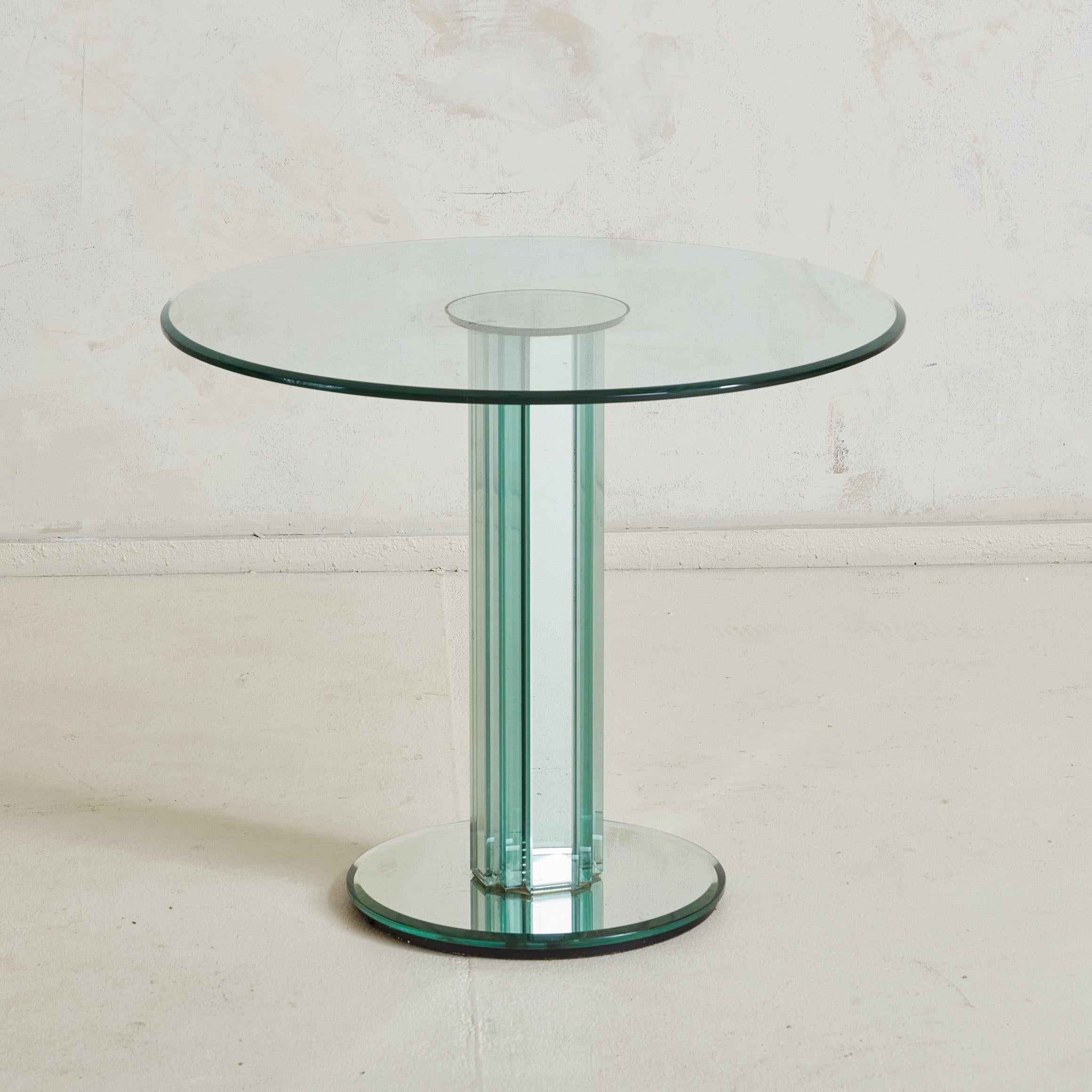 Un llamativo par de mesas auxiliares italianas con espejo atribuidas a Luigi Massoni para Gallotti & Radice en la década de 1980. Estas modernas mesas auxiliares presentan bases de pedestal redondas y columnas centrales de grueso cristal de espejo