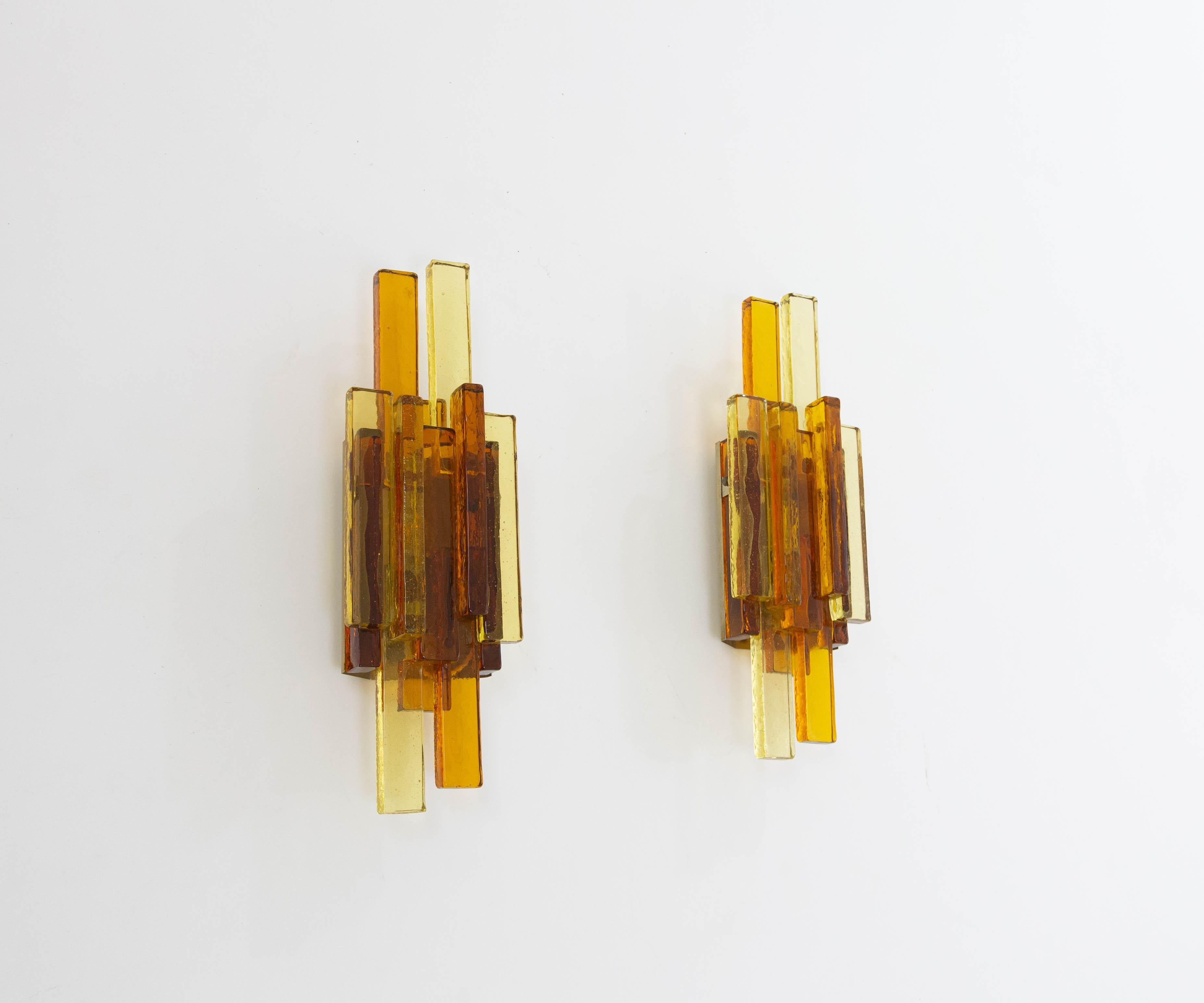 A pair of glass wall lamps No. 5104 designed by Svend Aage Holm Sørensen for his own company, Holm Sørensen & Co.

Beautifully designed with golden and amber colored glass, granting the lamps a classy appearance. 

The lamps are original and in very