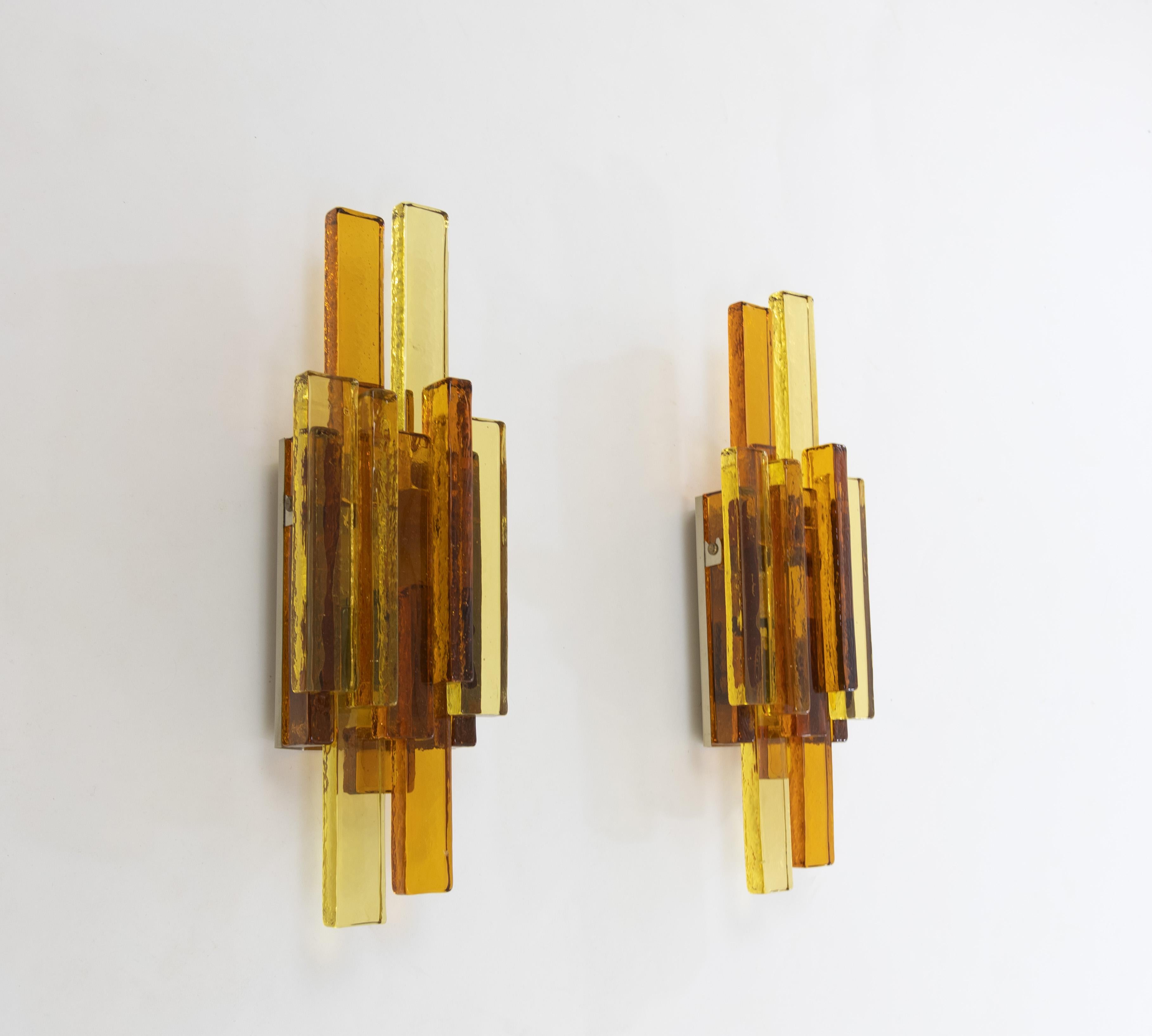 A pair of glass wall lamps No. 5104 designed by Svend Aage Holm Sørensen for his own company, Holm Sørensen & Co.

Beautifully designed with golden and amber colored glass, granting the lamps a classy appearance. 

The lamps are original and in very
