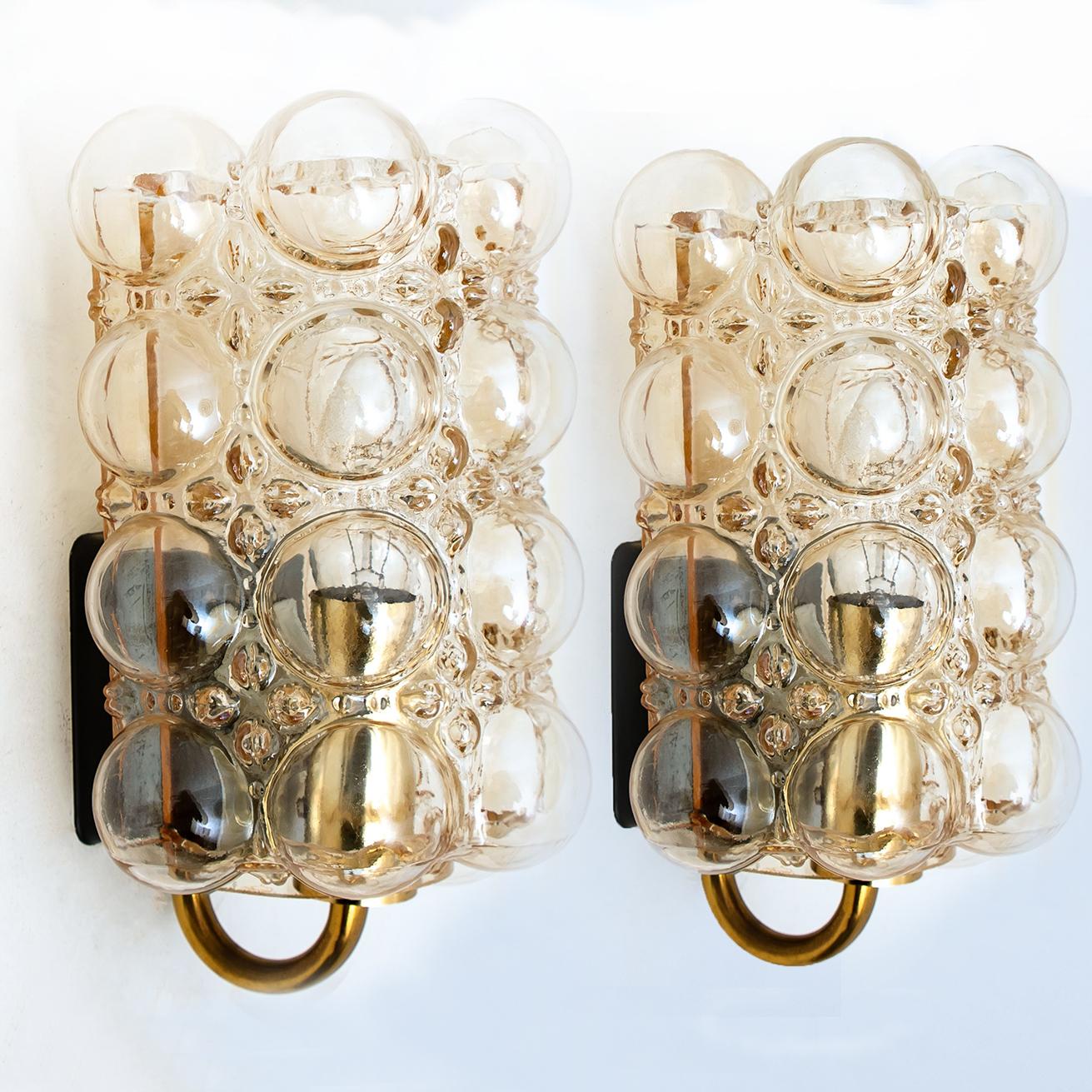 A pair of beautiful bubble glass wall lights designed by Helena Tynell for Glashütte Limburg. A design Classic, the amber colored or toned of the hand blown glass gives a wonderful and warm glow. 

Heavy quality and in excellent vintage condition.