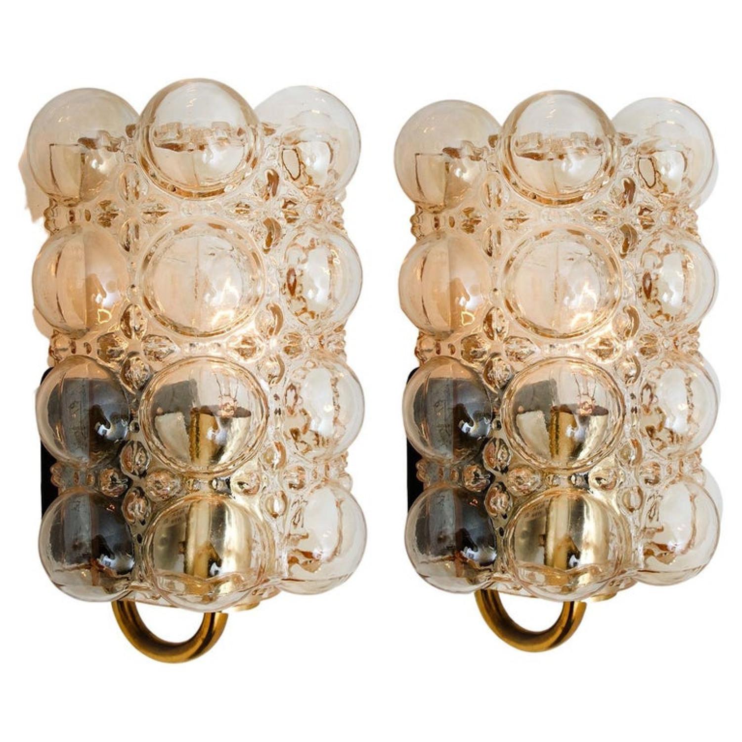 A pair of beautiful bubble glass wall lights designed by Helena Tynell for Glashütte Limburg. A design Classic, the amber colored or toned of the hand blown glass gives a wonderful and warm glow.xa0

Heavy quality and in excellent vintage condition.