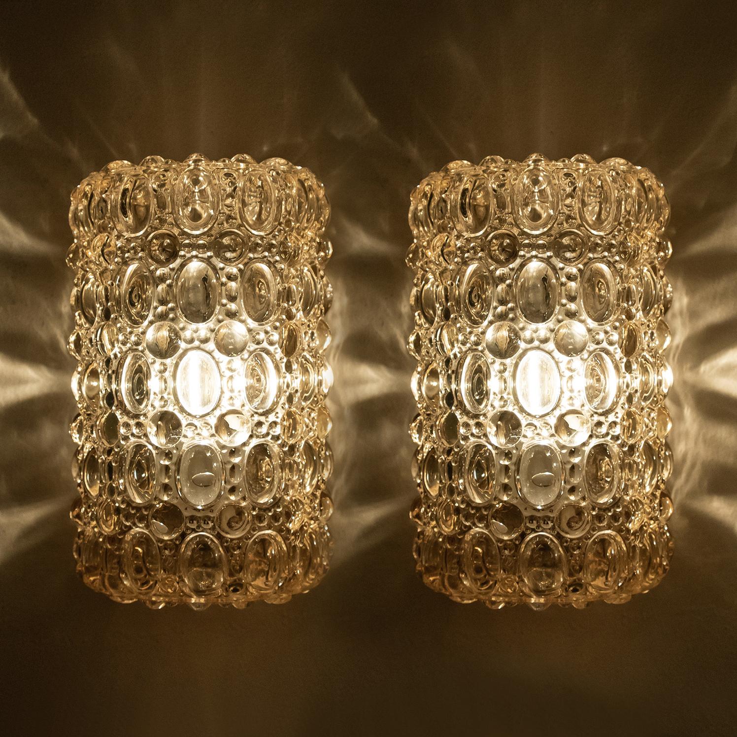 A pair of beautiful bubble glass wall lights designed by Helena Tynell for Glashütte Limburg. A design classic, the amber colored tone of the handblown glass gives a wonderful and warm glow. 

Heavy quality and in excellent vintage condition.