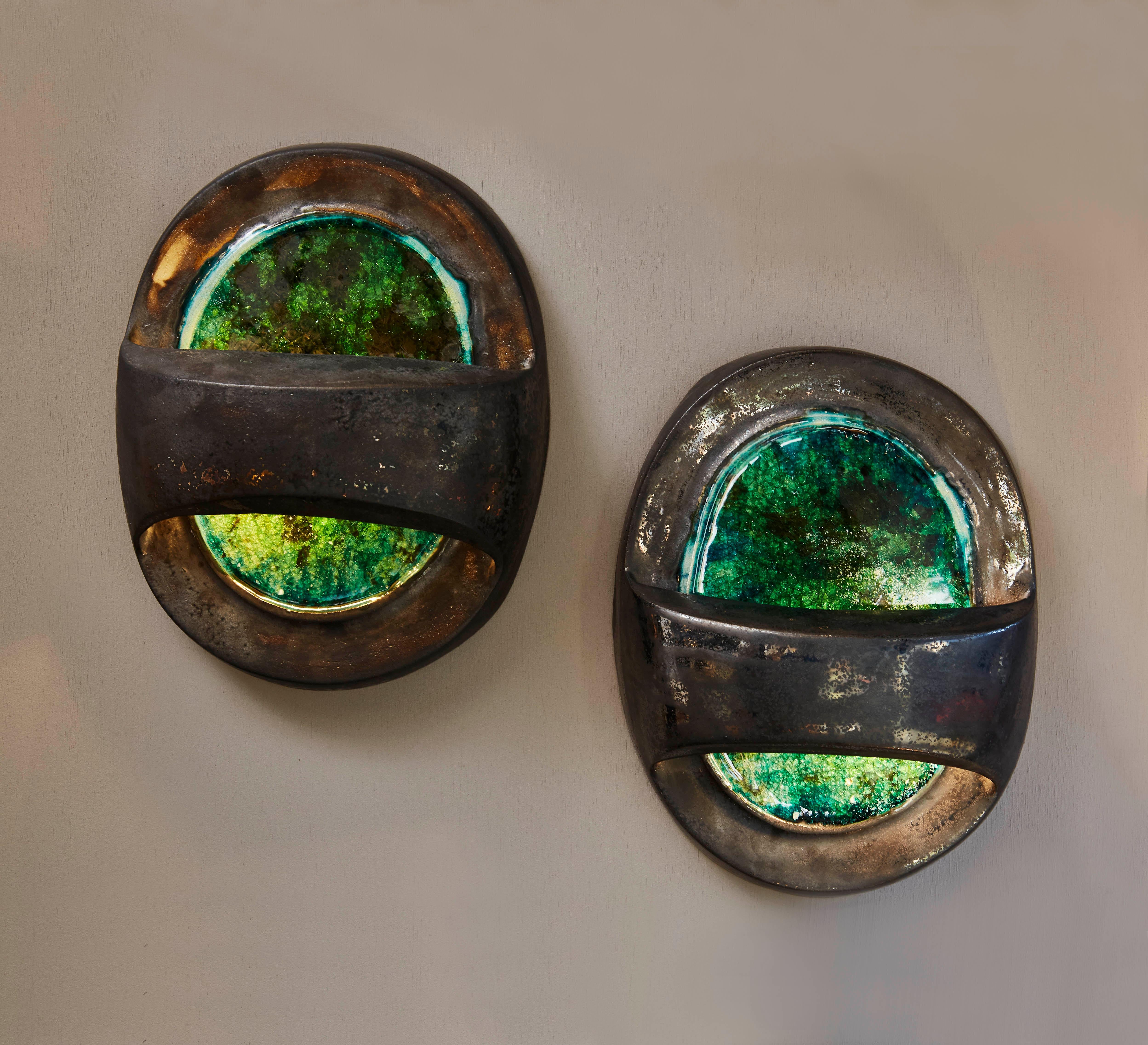 Pair of beautiful wall sconces called Callisto, named after one of Saturn's moon.

The ceramic has a copper glaze that gives it its crystalline look.

  
