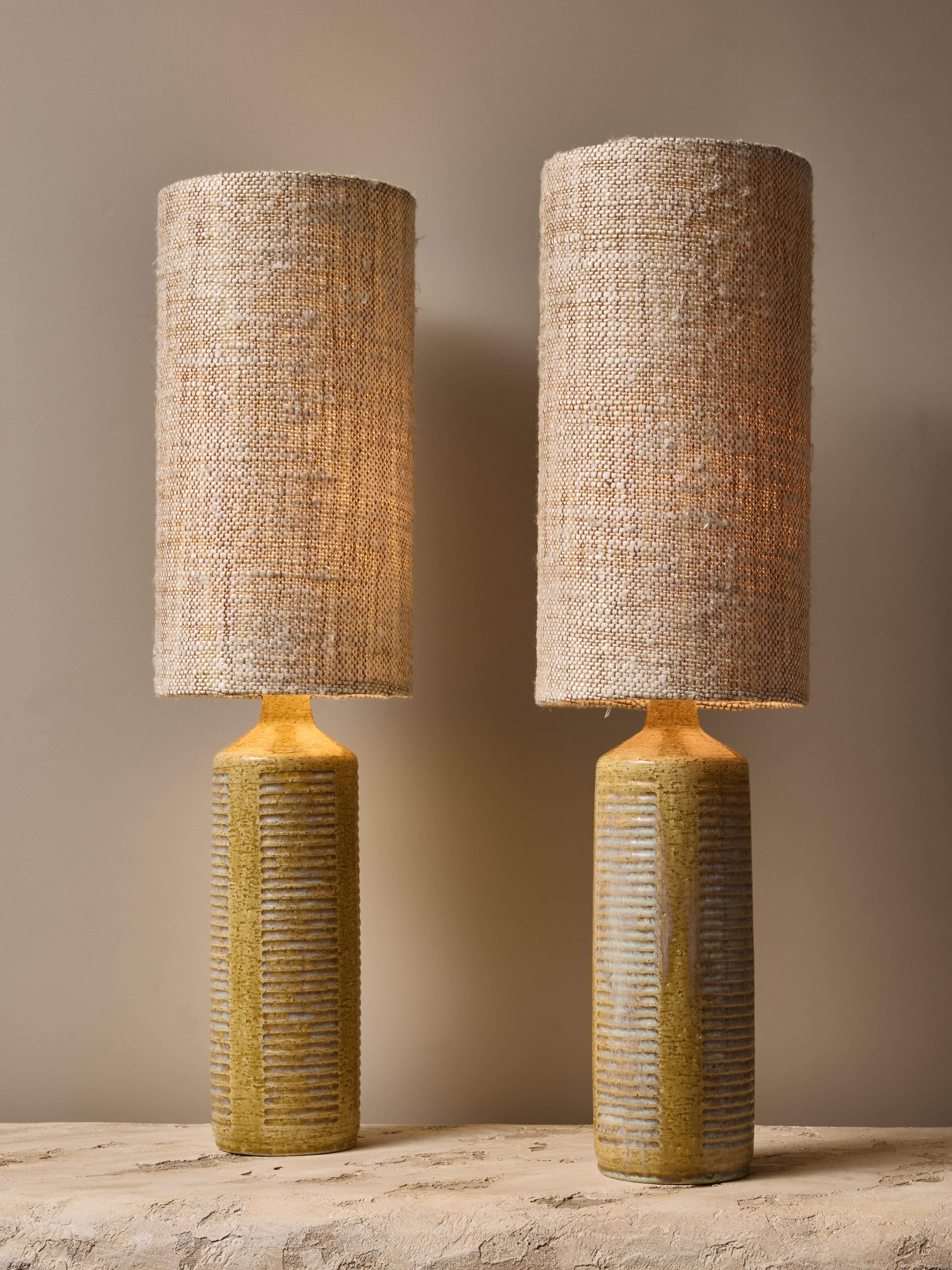 Paire de lampes de table modèle DL27 en céramique par le designer danois Per Linneman-Schmidt pour la manufacture Palshus. Les lampes sont recouvertes d'une glaçure verte texturée avec des touches de sarcelle dans certaines rainures